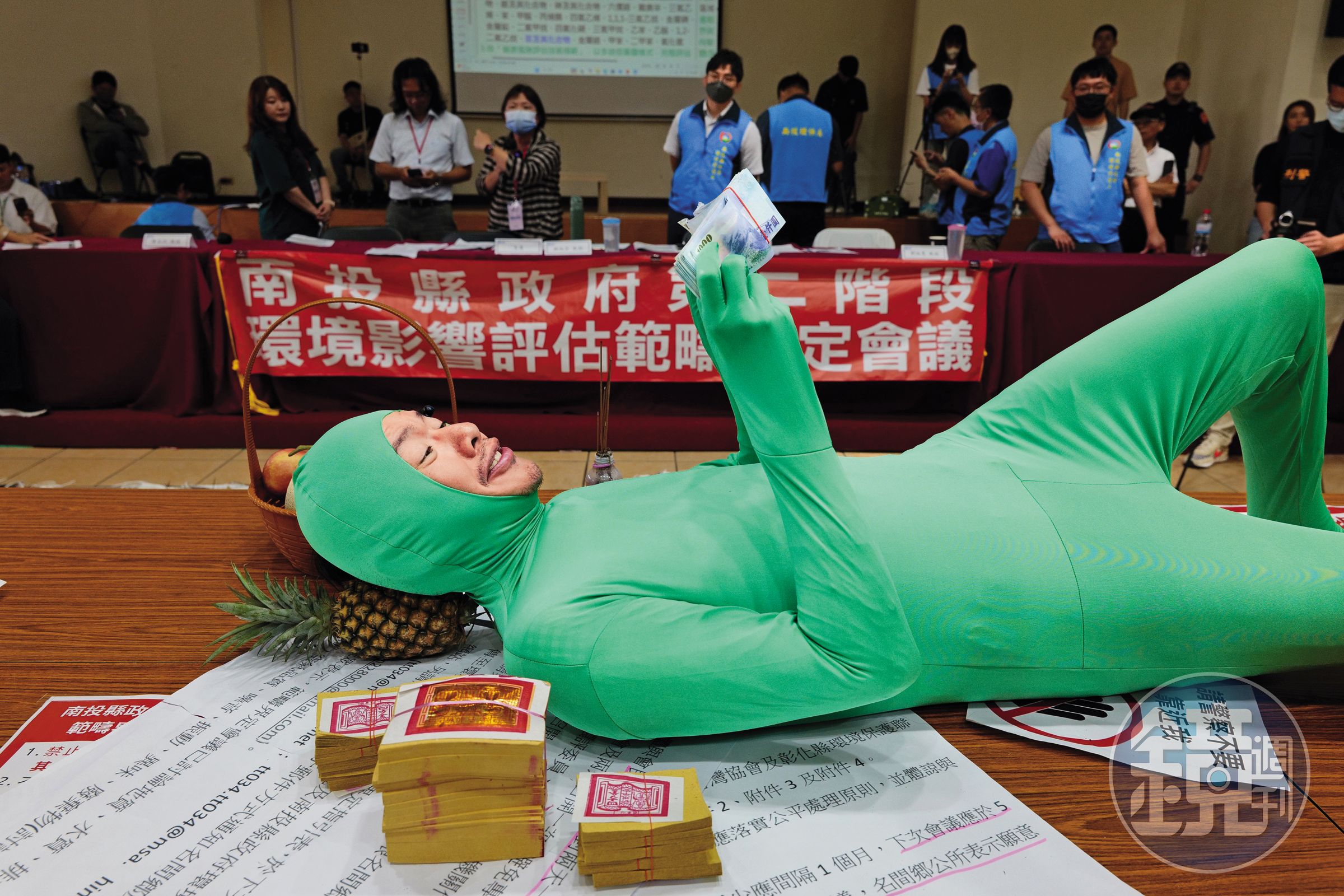 常行深的新造型是這件綠幕衣,幾次穿著它向官員撒鈔票,諷刺南投縣府決定興建焚化爐只因某些人想賺飽飽。