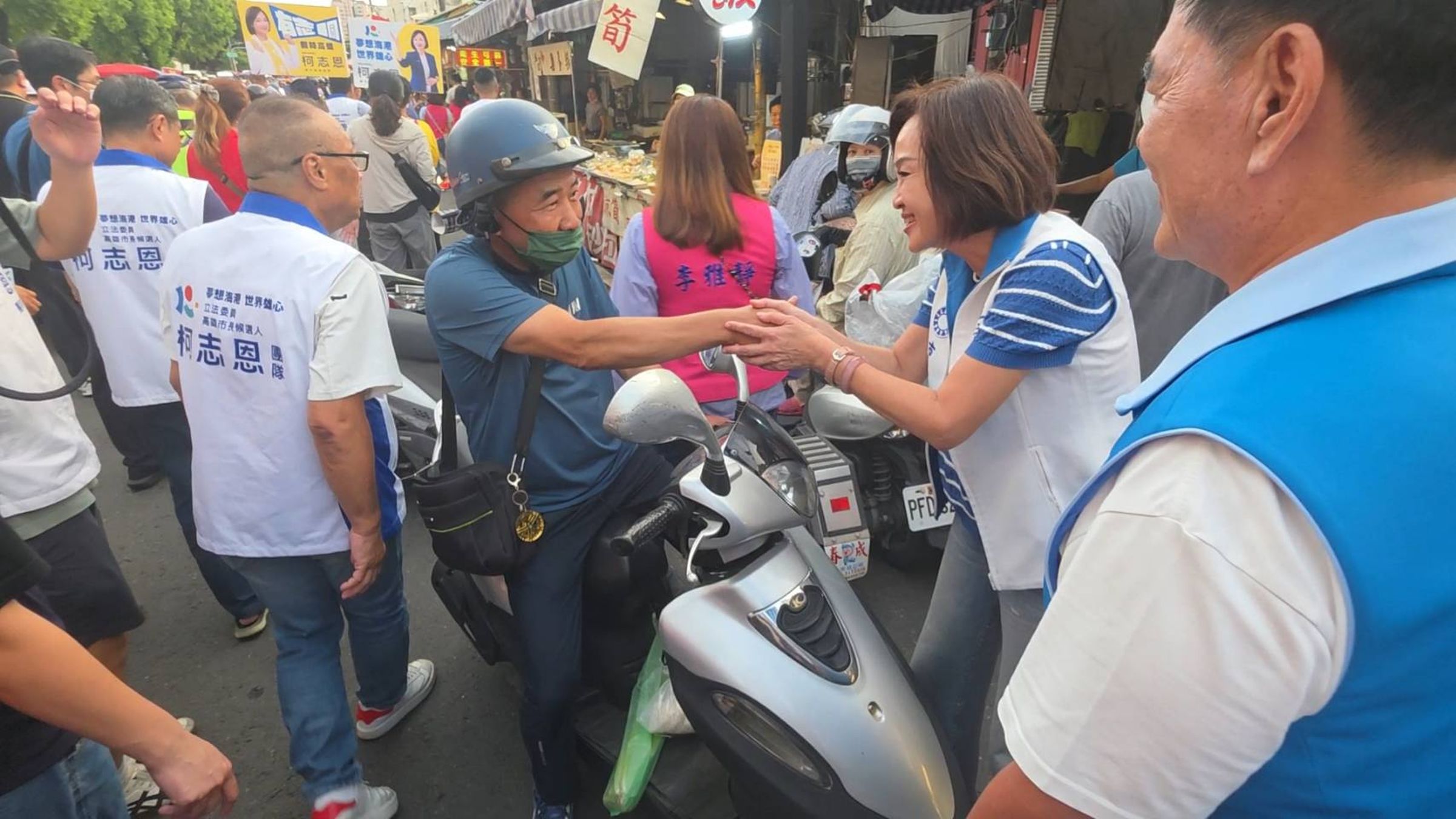 柯志恩掃街途中,與騎車路過的民眾握手致意。