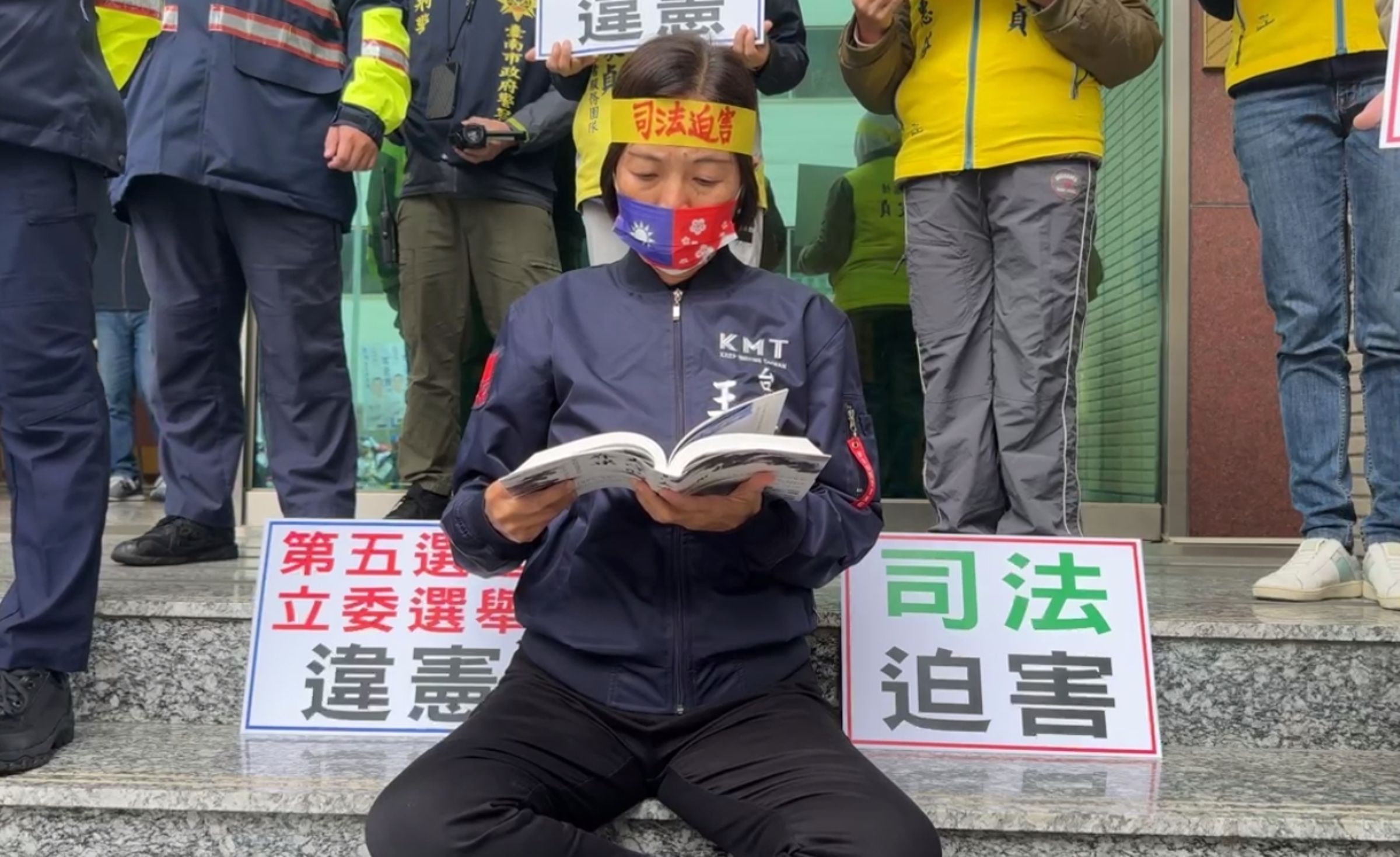國民黨王家貞因偽造文書罪被判緩刑,尚未期滿,無法登記為候選人,今在候選人號次抽籤的現場外靜坐抗議。(翻攝自王家貞臉書)