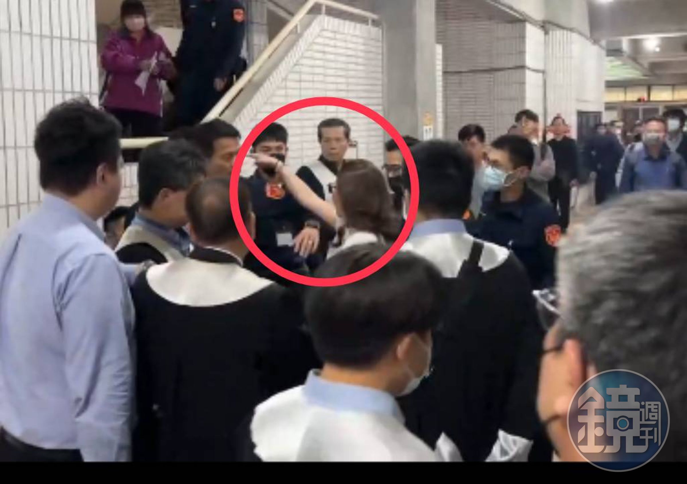 林女（紅圈者）在法院裡東踢西踹，橫性跋扈，未見任何女警出面，僅見男警團團圍住、束手無策。（讀者提供）