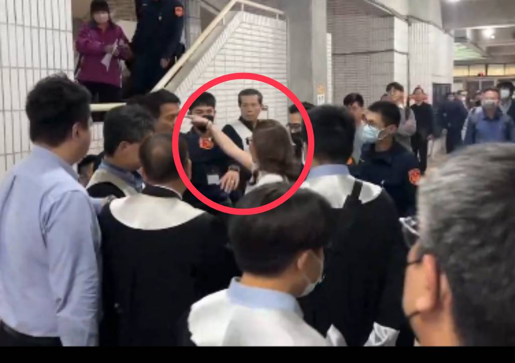林女（紅圈者）在法院裡東踢西踹，橫性跋扈，未見任何女警出面，僅見男警團團圍住、束手無策。（讀者提供）