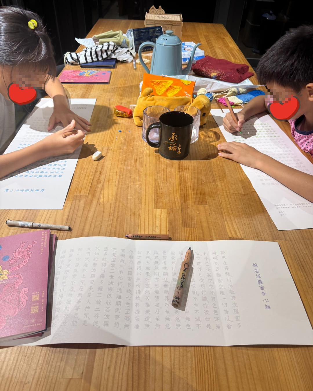 一雙兒女低頭抄心經。（翻攝林慈惠臉書）