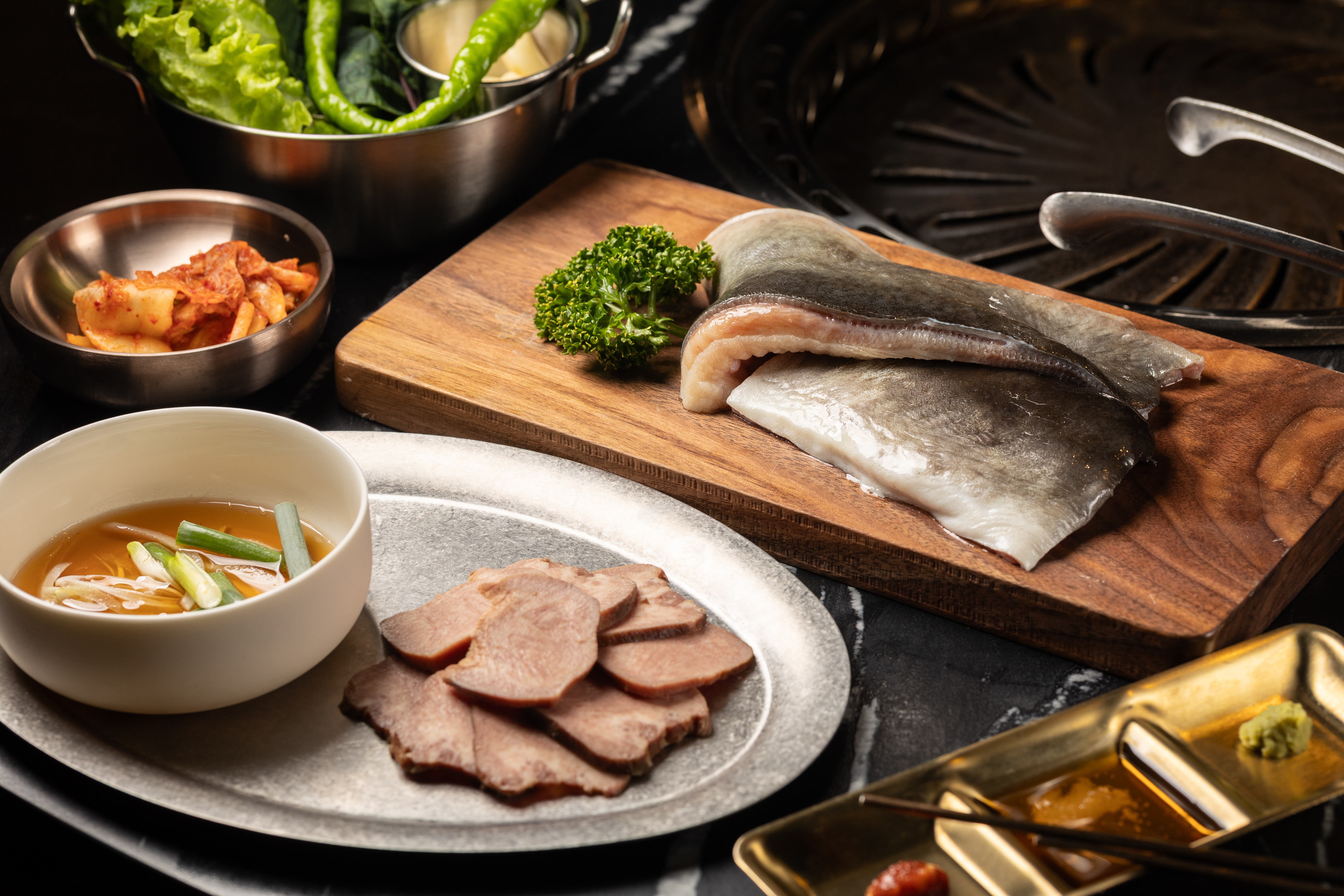 食材選擇也很用心，台灣冷泉飼養的「活水黑鰻」（後，890元／小份）口感Q彈無土味；牛舌（前）則會由專人爆炒後搭配拌飯一同享用。