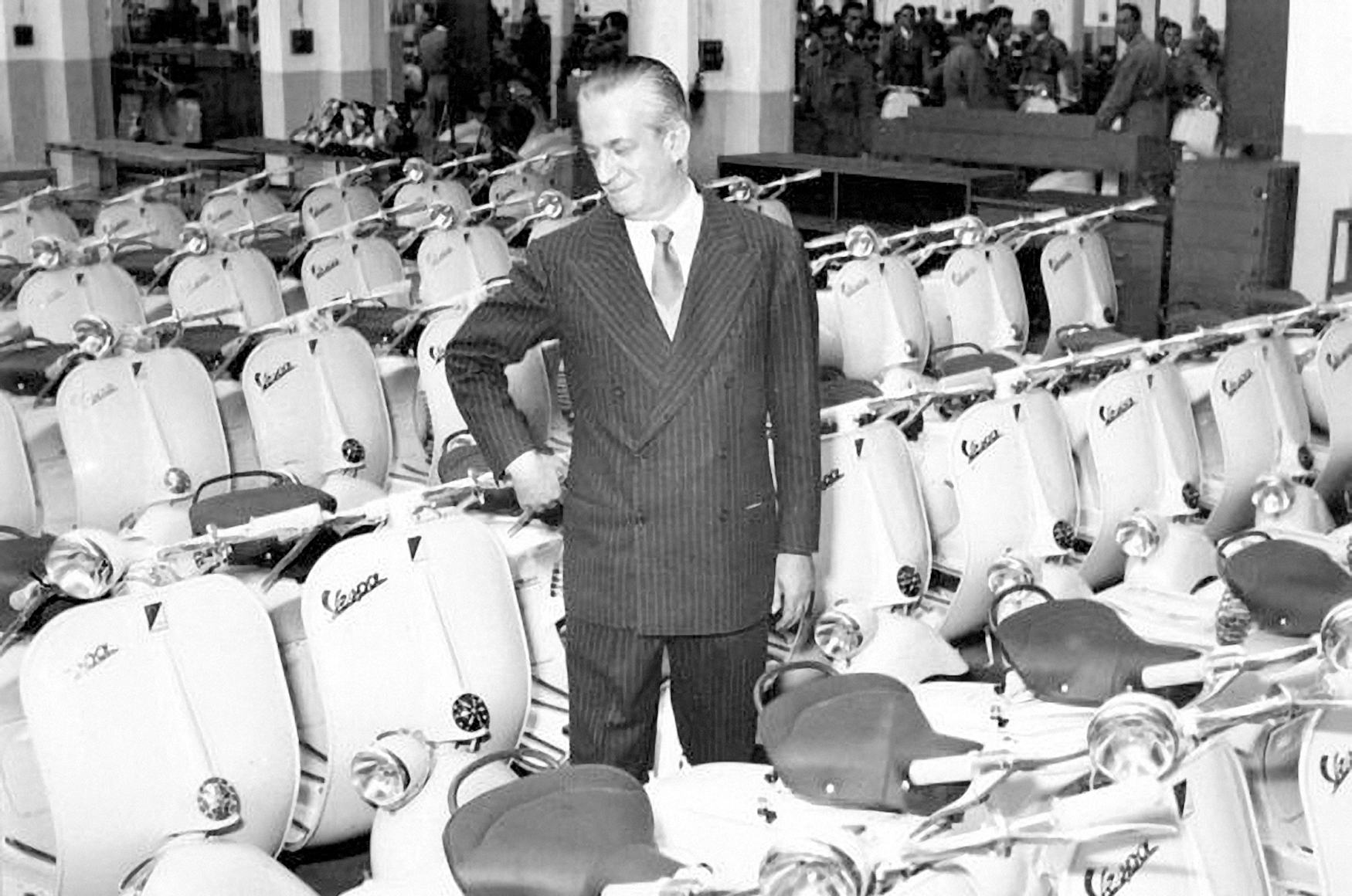 1956年，Enrico Piaggio (1905–1965)站在Pontedera廠Vespa車海前，慶祝品牌誕生以來生產的第一百萬輛機車。