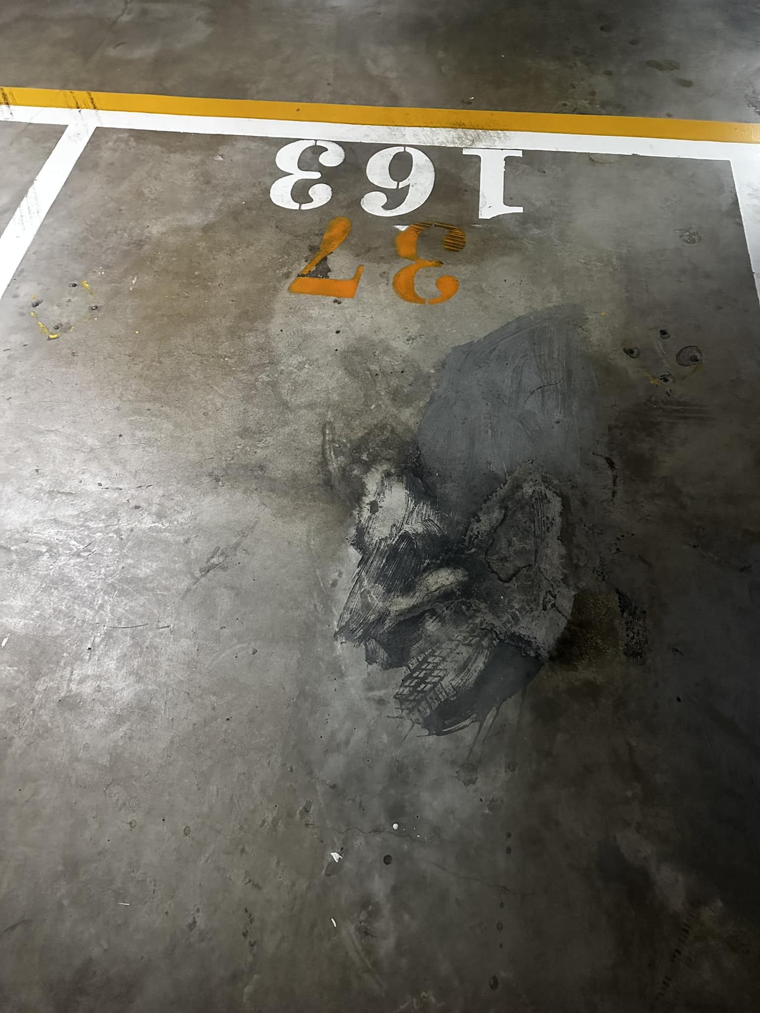 有台灣網友在停車場見到輪胎壓紋，仔細一看整體痕跡就宛如「變身的巨人」的頭像。（翻攝自路上觀察學院）