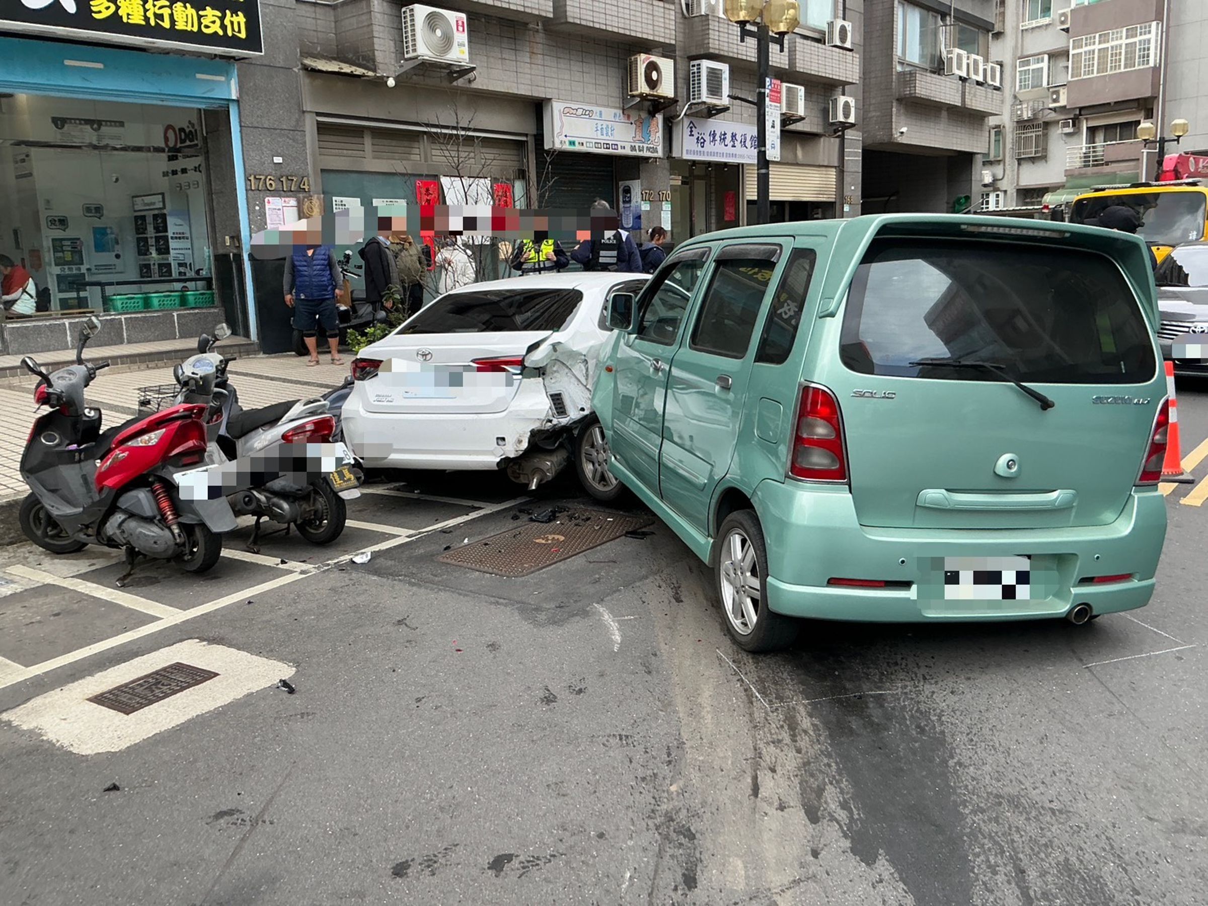 胡女駕車碰撞白車之後，不僅將白車推至路邊，還波及停車格的機車。（翻攝畫面）