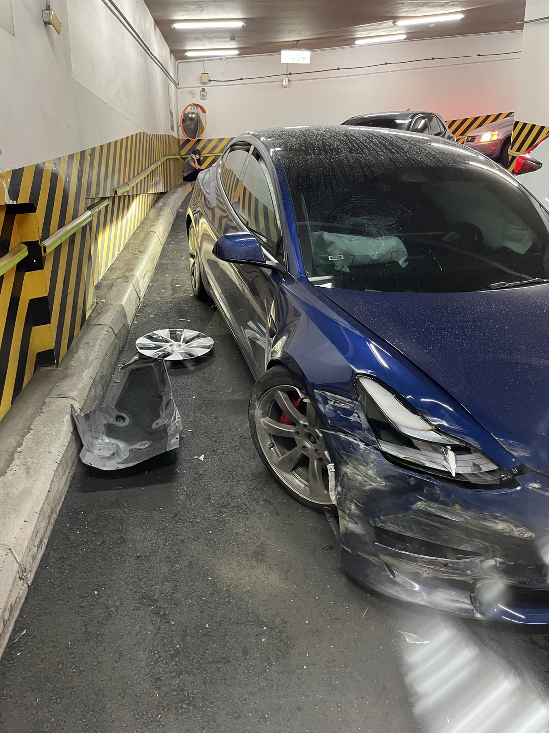 邱銘乾夫婦駕駛的特斯拉在地下停車場車道突然暴衝,導致車頭毀損。(讀者提供)