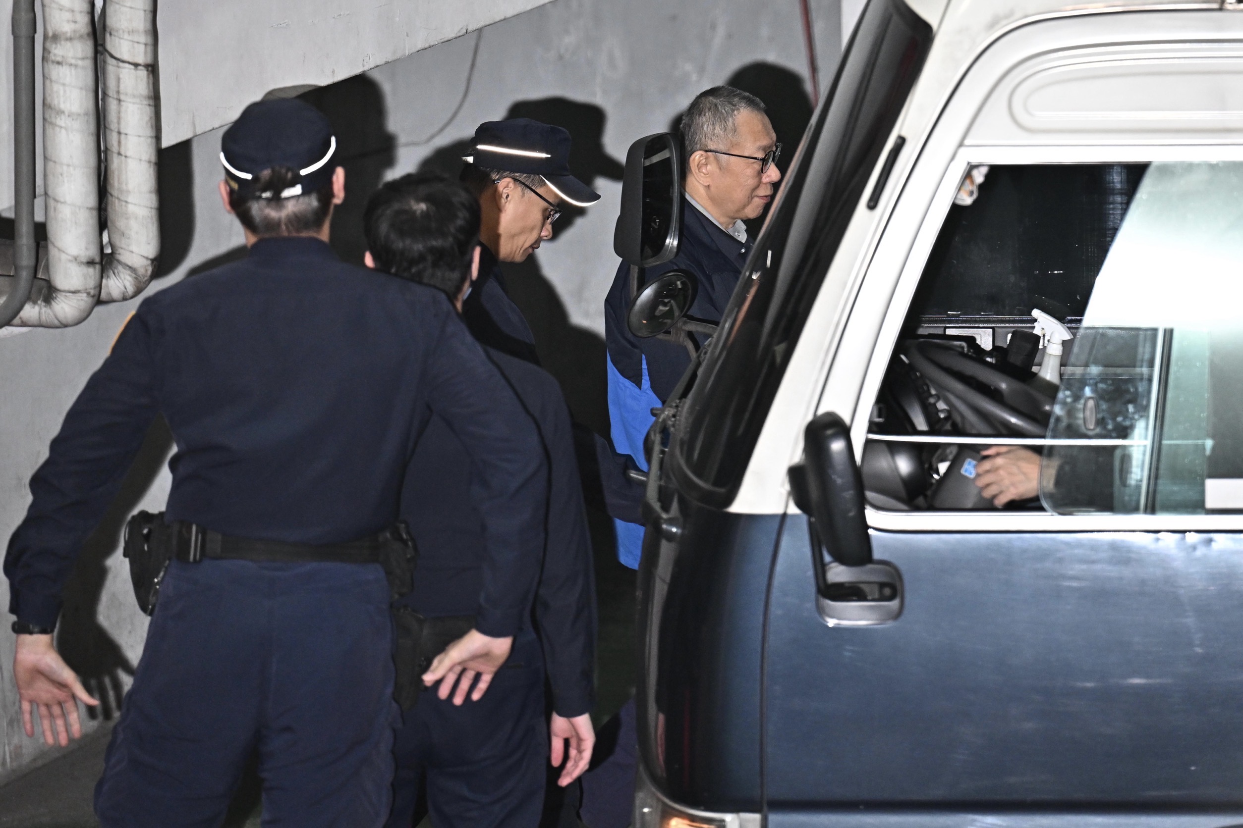 柯文哲走回囚車路上，突露出神祕微笑。