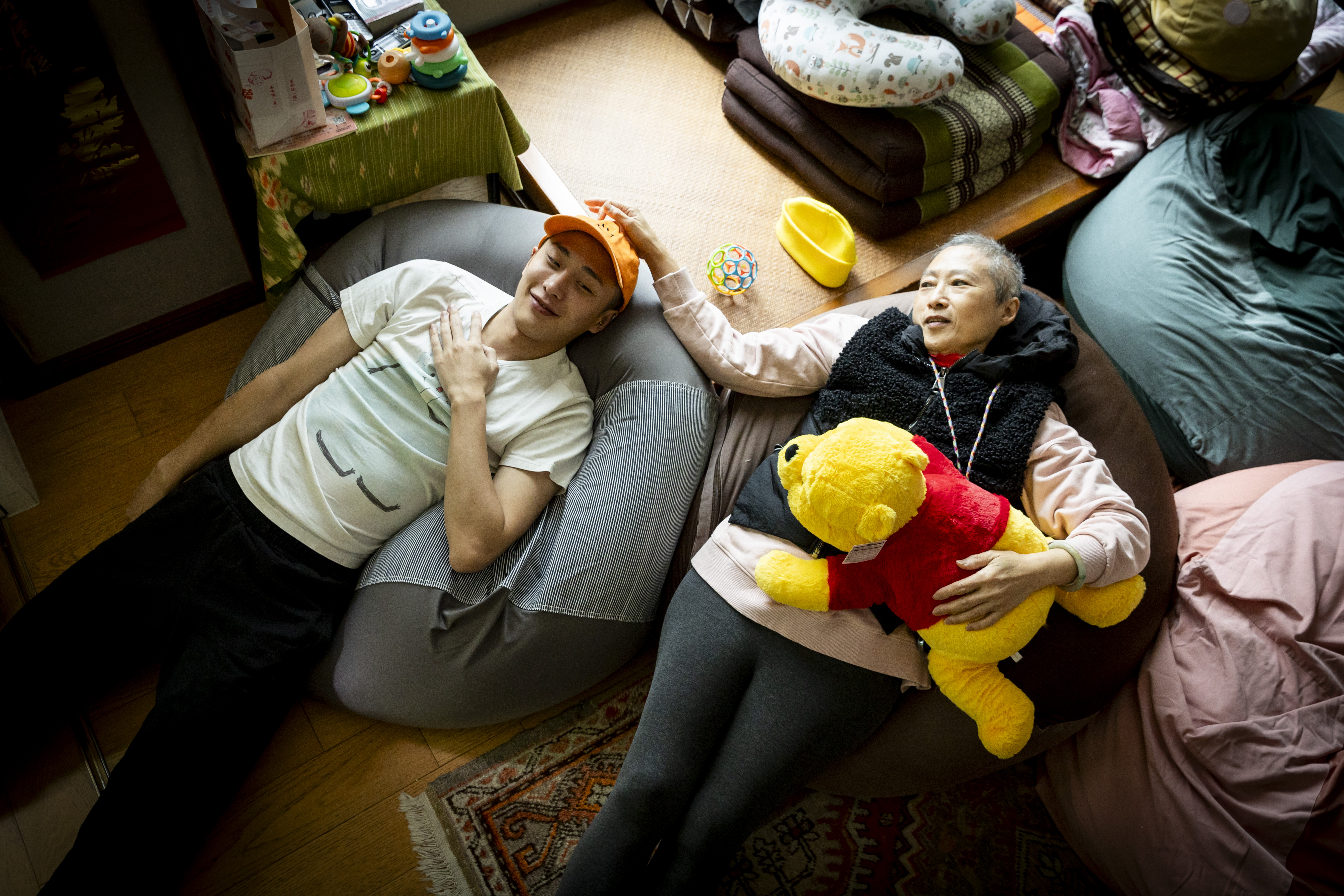 為了符合曹里歐的慵懶性格，我們索性請他和曹媽媽躺著拍照，意外捕捉到母子的溫馨時刻，獲2025台灣新聞攝影大賽肖像類第三名。