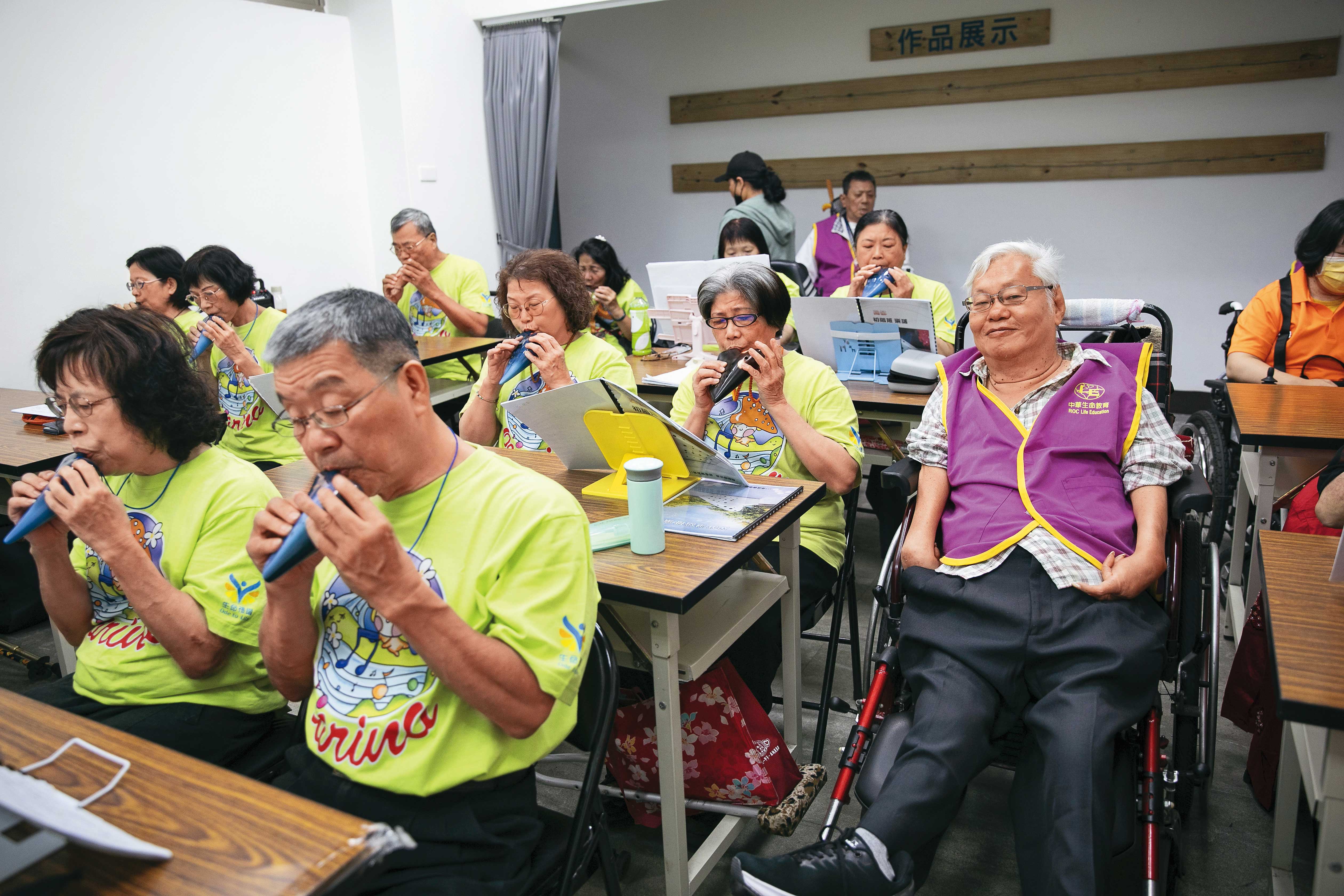 生命禮讚綜藝團的身障者每週都會練習陶笛，劉天富（右）有時也去探班。