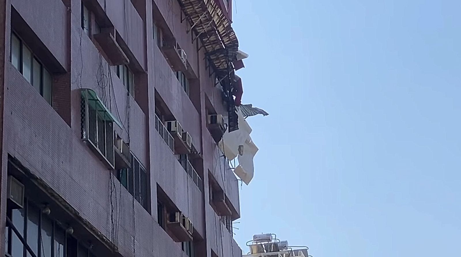 大樓外牆鐵皮搖搖欲墜。(翻攝記者爆料網)