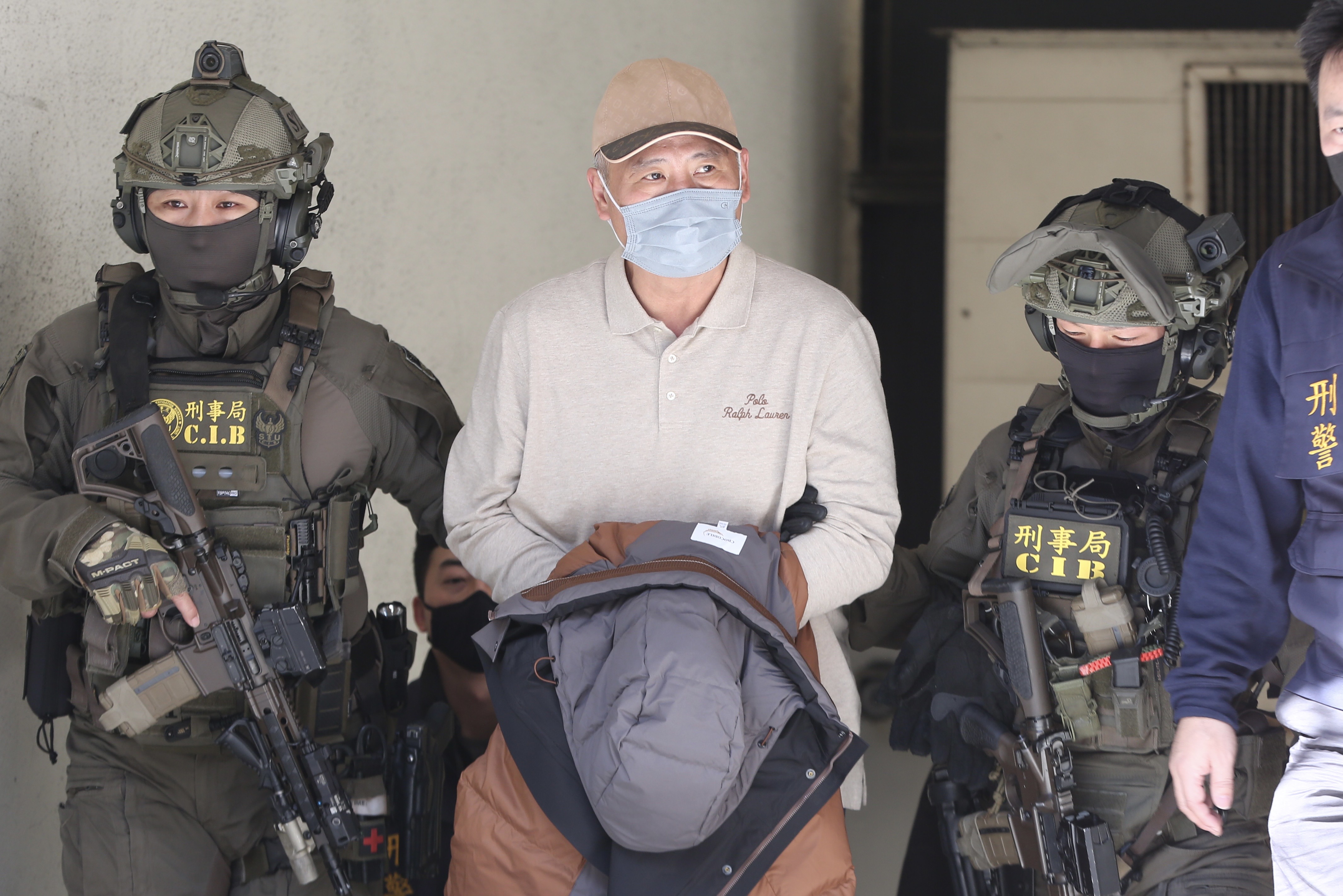 四海幫幫主張存偉移送北檢複訊，2名除暴特勤隊荷槍戒護。（鏡報姜永年）