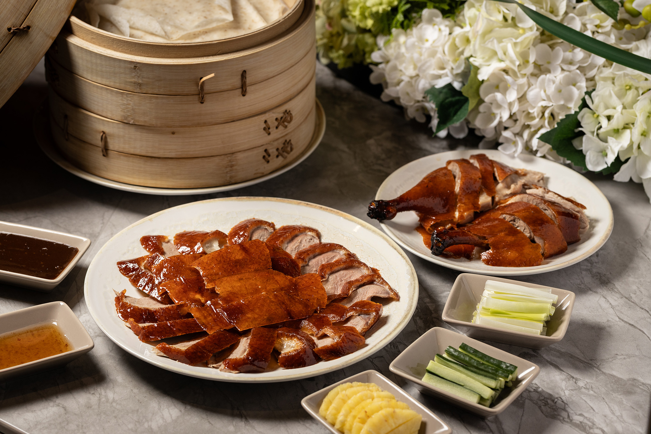 位於台北信義區的粵菜餐廳「芯聚苑」，招牌菜「經典片皮鴨」搭配鳳梨片與冰梅醬，為傳統菜注入嶄新風味。（一吃，2,380元／份）