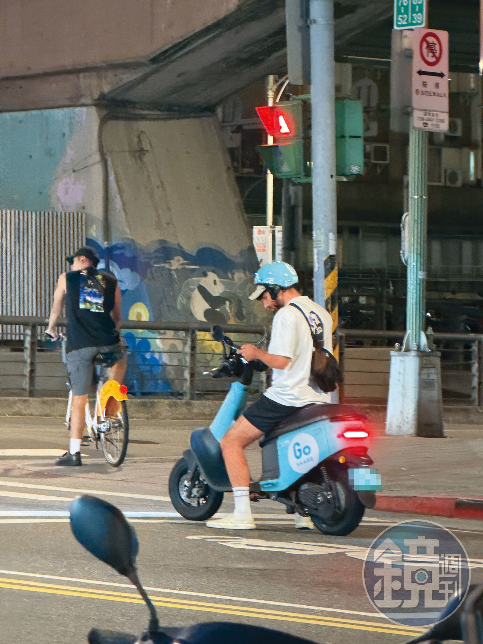 酷被民眾目擊在台北市街頭違規，騎車滑手機。（讀者提供）