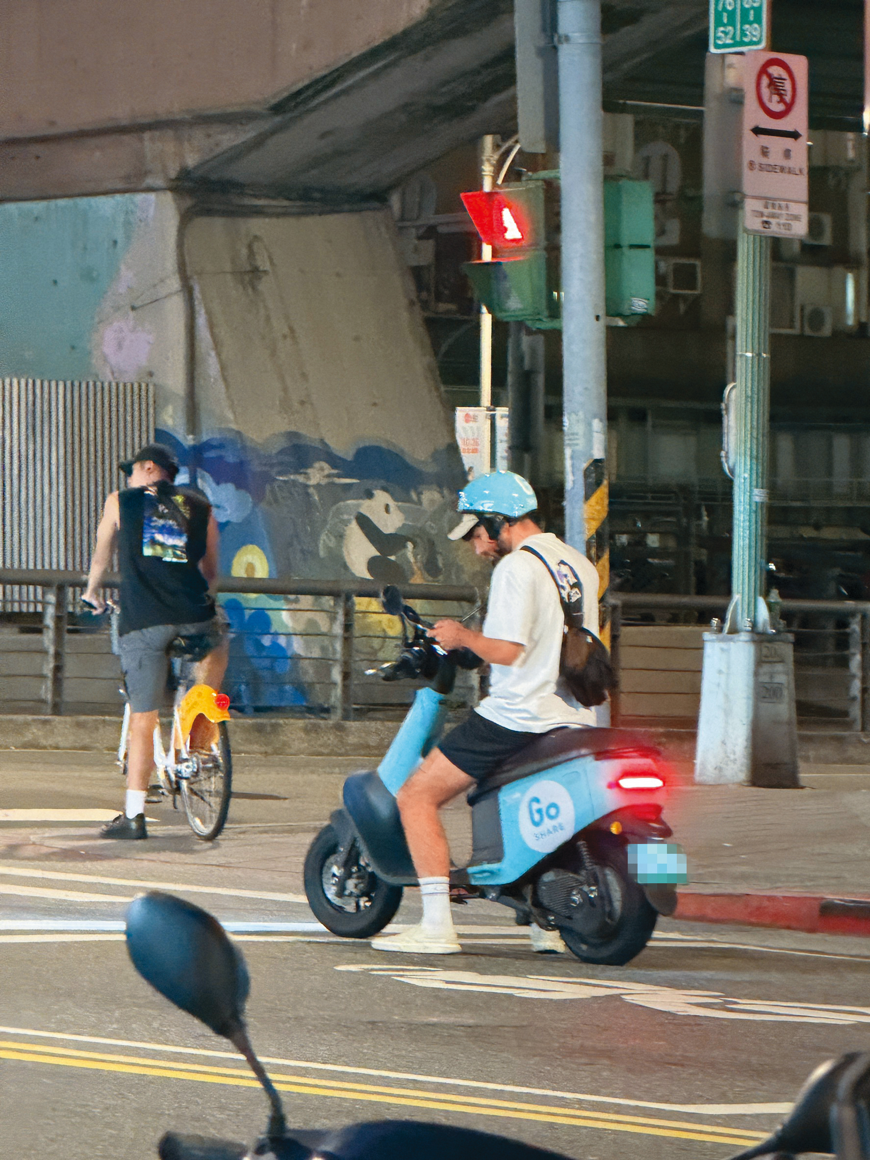 酷被民眾目擊在台北市街頭違規,騎車滑手機。(讀者提供)