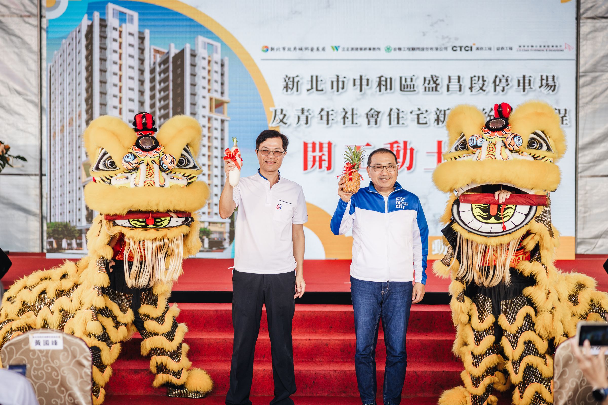 市長侯友宜與城鄉局長黃國峰接下祥獅獻上的好彩頭，祈福工程順利完工。