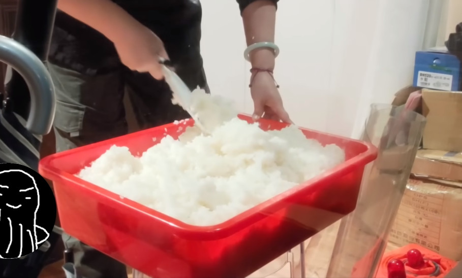 廚師用塑膠桶拌醋飯，旁邊還堆置雜物，被網友指出作法不專業，有食安疑慮。（翻攝YT頻道「蝦土豆」）