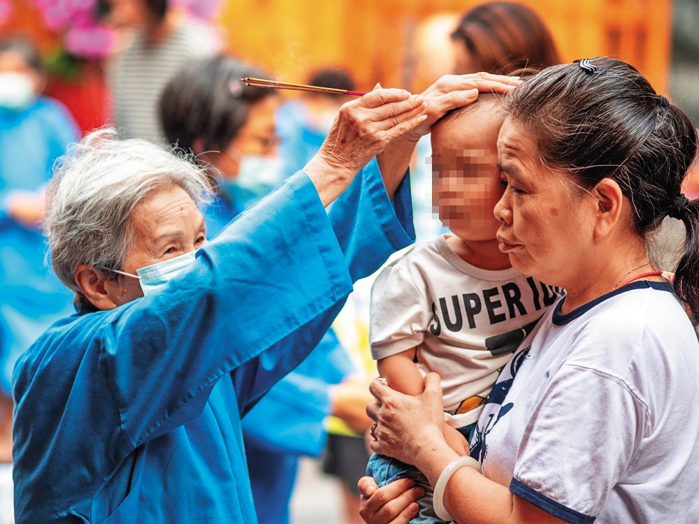 行天宮效勞生阿嬤收驚帶給大人、小孩滿滿平安,為廟裡一大特色。