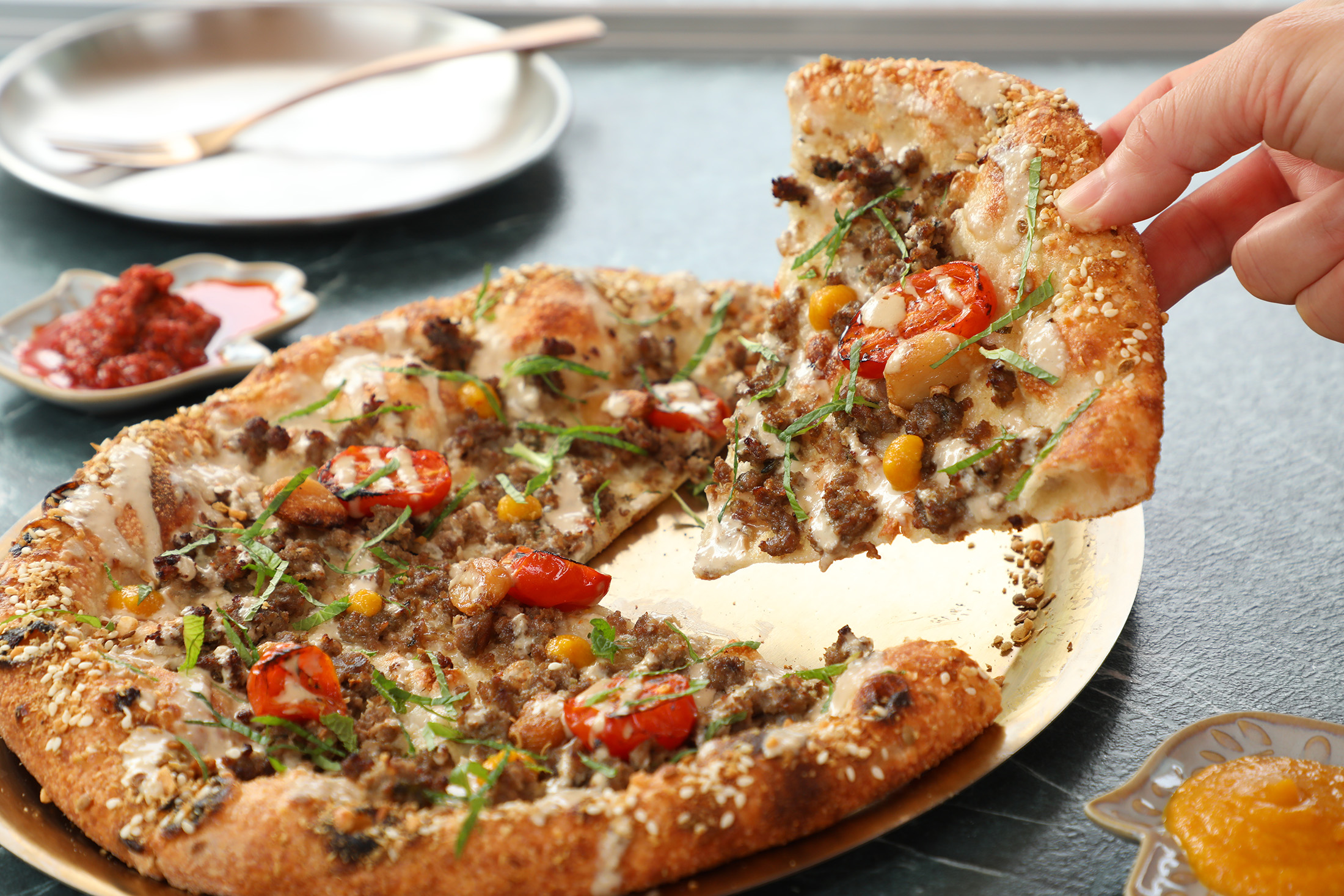 Pizza Hamsa 人氣口味「Kebab卡霸牛披薩」以漢堡肉搭配烤小番茄、油封大蒜、白芝麻醬、薄荷絲與中東青芒果。（390元／份）