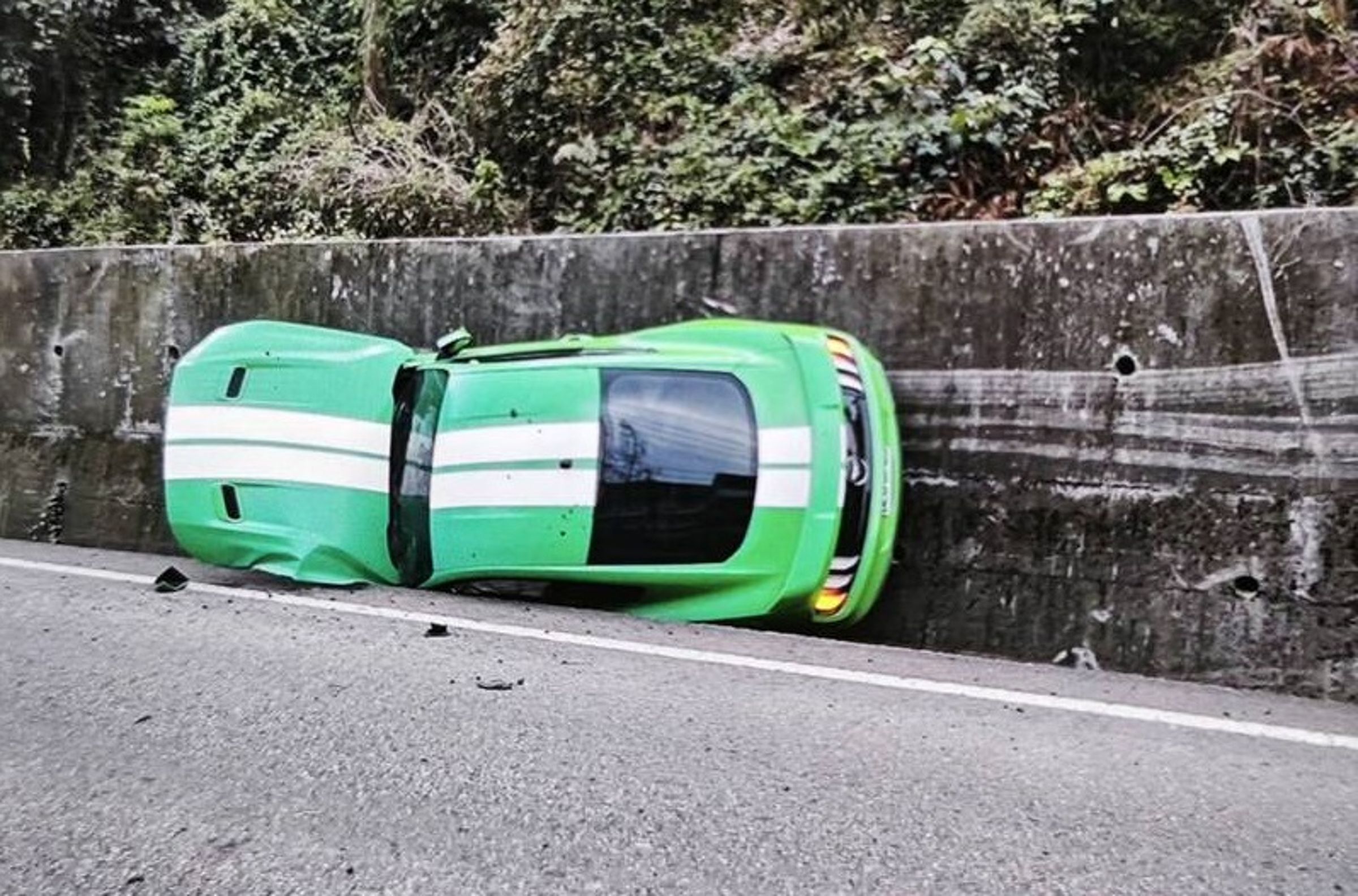 南投縣埔里鎮30日一輛跑車在山路失控衝撞，整輛車卡在邊溝。（警方提供）