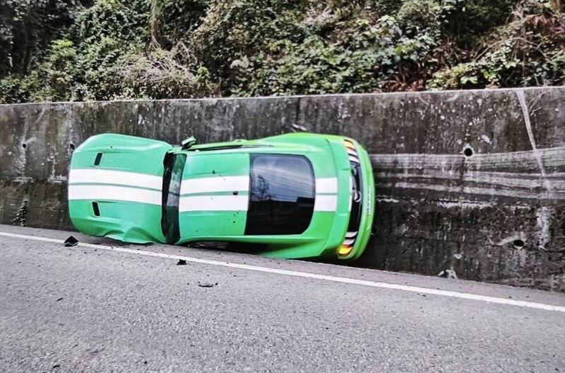 南投縣埔里鎮30日一輛跑車在山路失控衝撞,整輛車卡在邊溝。(警方提供)