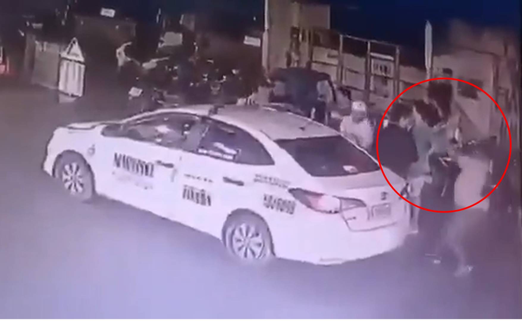2名日本人於菲律賓馬尼拉一下計程車，隨後1人（紅圈處）跑來朝他們開槍奪走財物。（翻攝X）