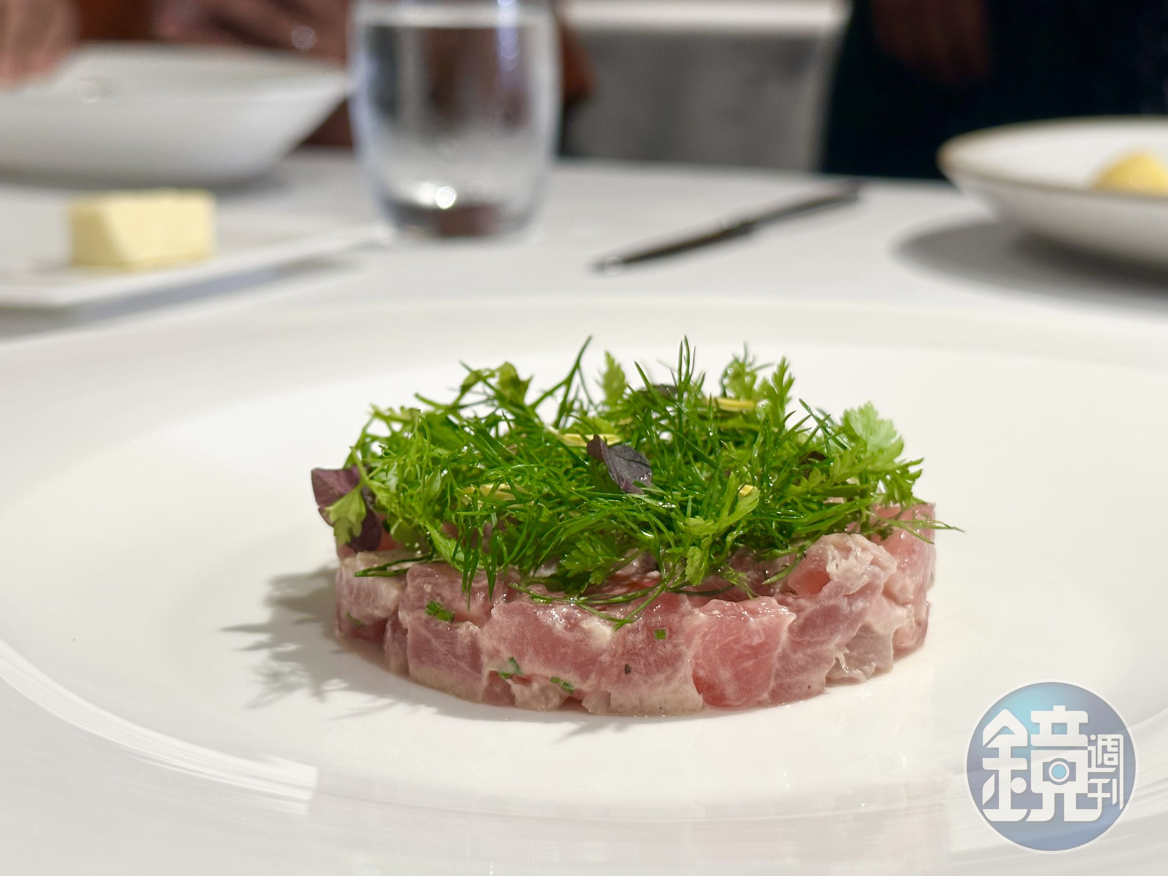 「鮪魚塔塔」魚肉外層扎實，裡頭Q軟，配著綜合香草，味道清爽，紅李果肉增添口感上的變化。（套餐菜色）