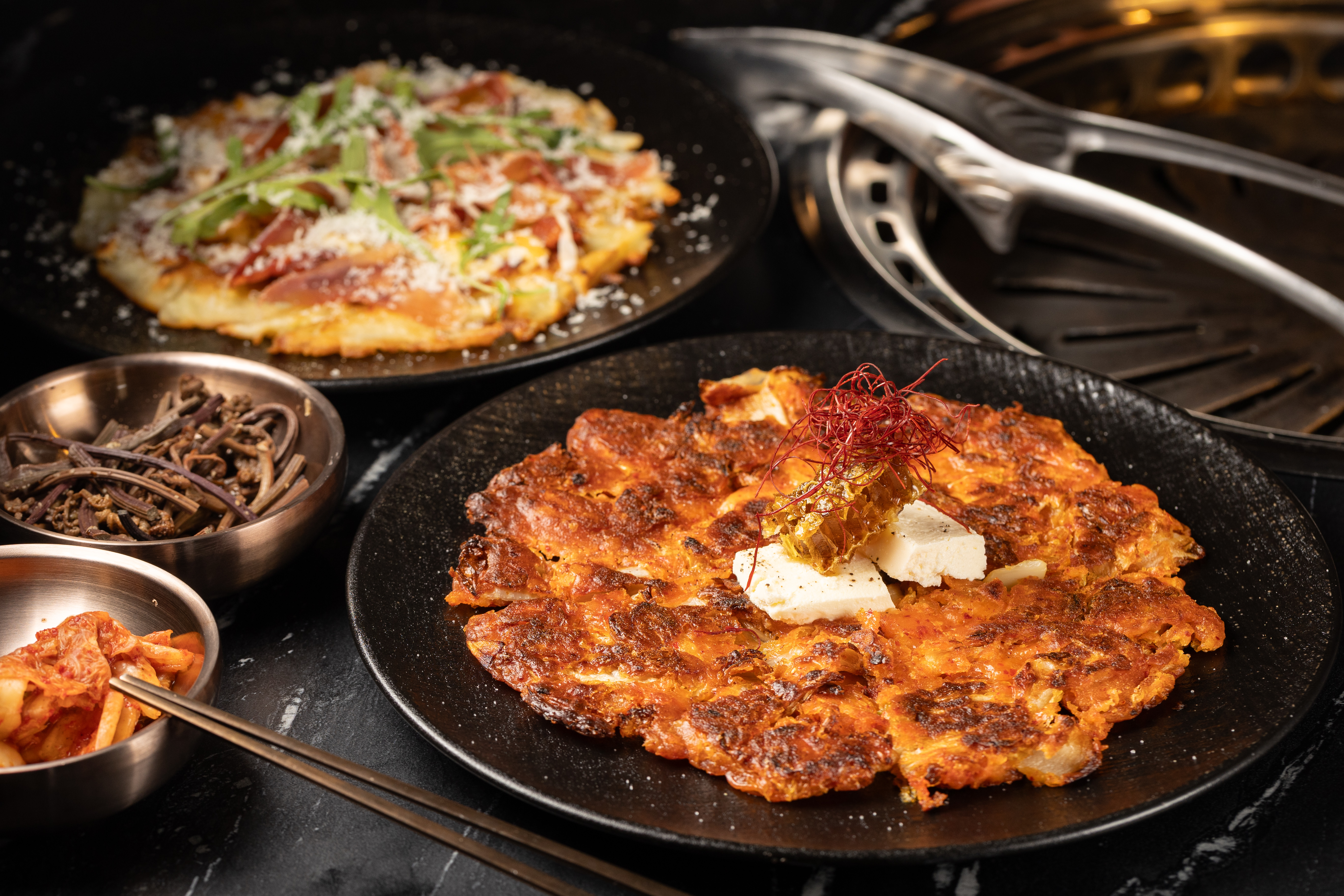 鹹甜口味的「蜂蜜起士泡菜煎餅」（前，298元／份） 與煎得外酥內軟的「起司馬鈴薯煎餅」（後，358元／份）都是想吃澱粉時的最佳選擇。
