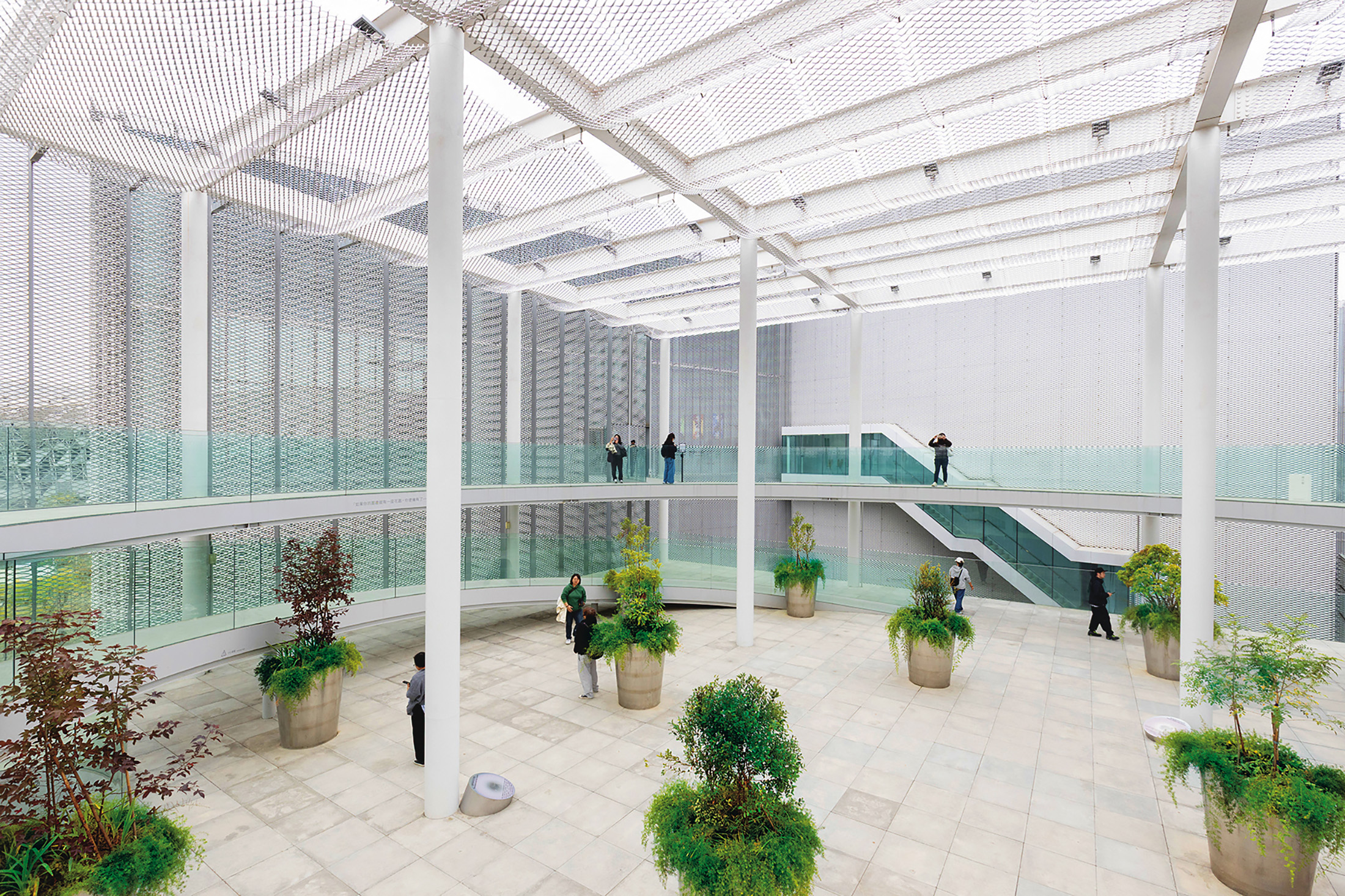 文化之森是美術館與圖書館之間的挑空半戶外屋頂花園，以金屬擴張網打造外牆，使空間保有穿透性。