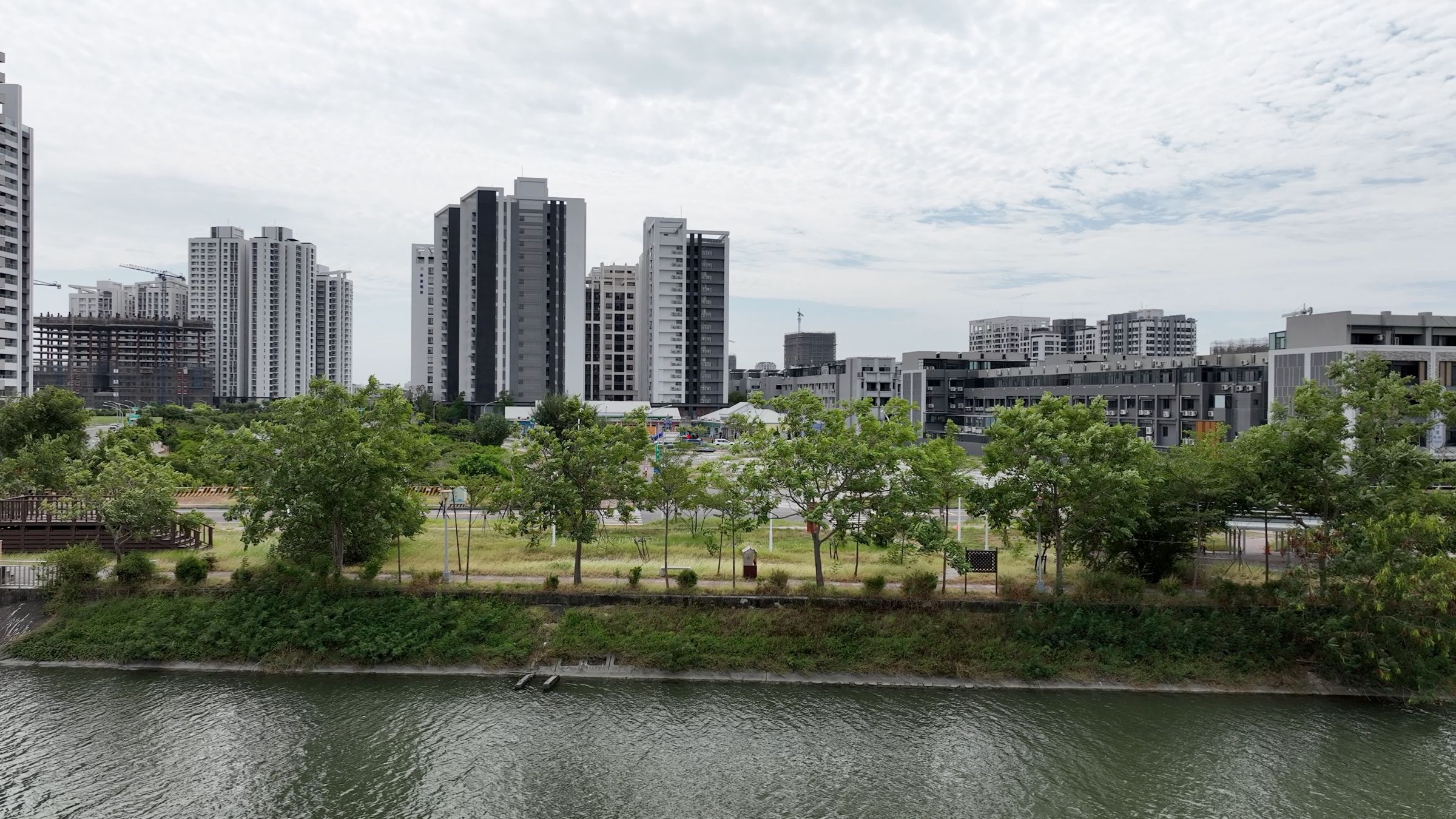 九份子重劃區以「西雅圖藍綠城市」為藍圖打造，是全台首座低碳示範社區，將綠意生態與永續理念融入城市肌理，打造一座會呼吸的宜居新城。