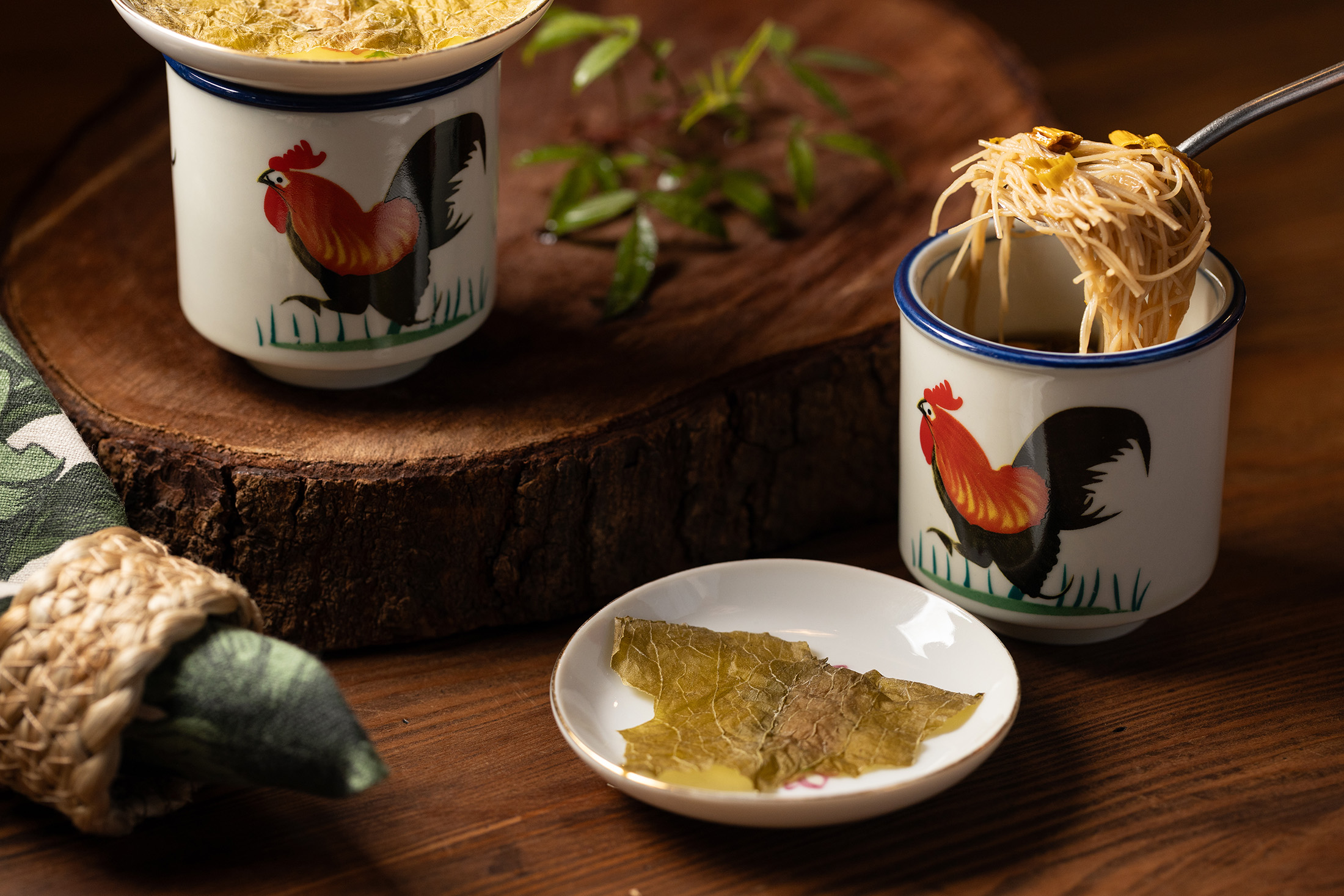 「米粉湯」以峨眉東方美人茶為靈感，湯底由酸菜、蘿蔔乾與10種蔬菜熬出鮮甜，配上柴燒金針花的煙燻感，重塑新竹人記憶中的米粉湯。
