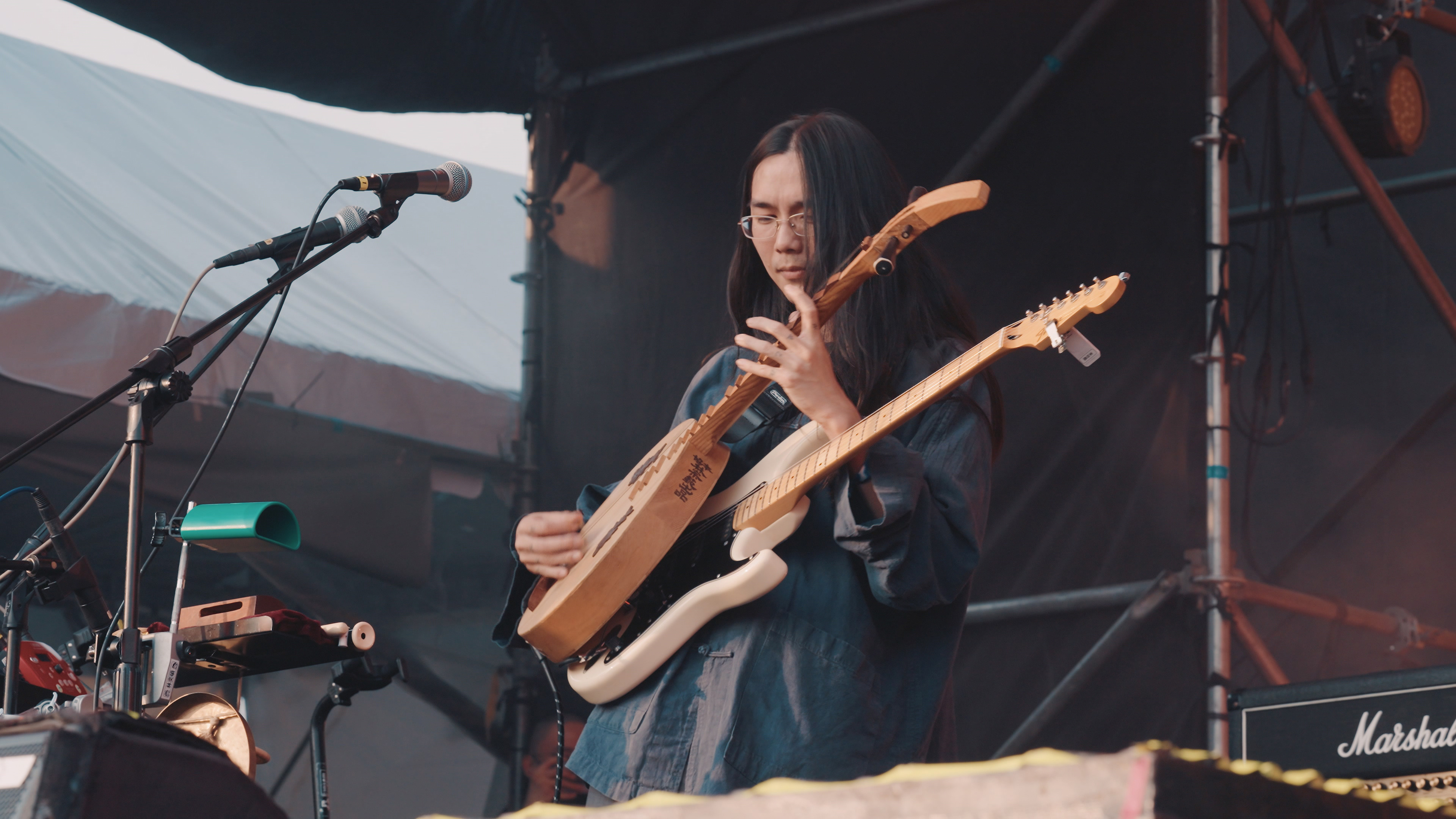 百合花樂團核心人物林奕碩常以長柄月琴、電吉手交替演奏。（公視提供）