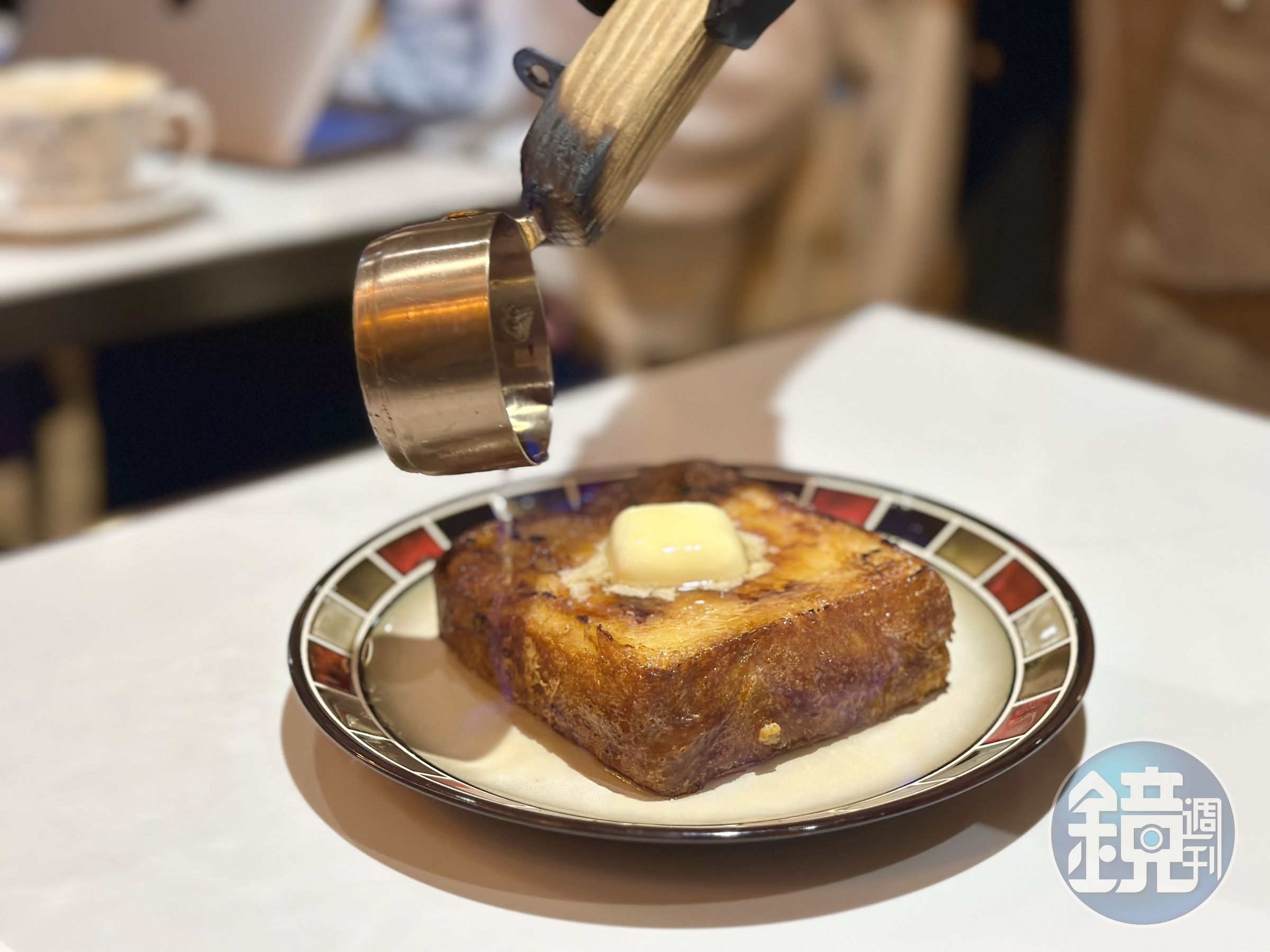 「火焰橙香蜂蜜」會在桌邊淋甜酒再點火，讓法式布蕾吐司吃來外脆內鬆，有淡淡酒香。（360元／份）