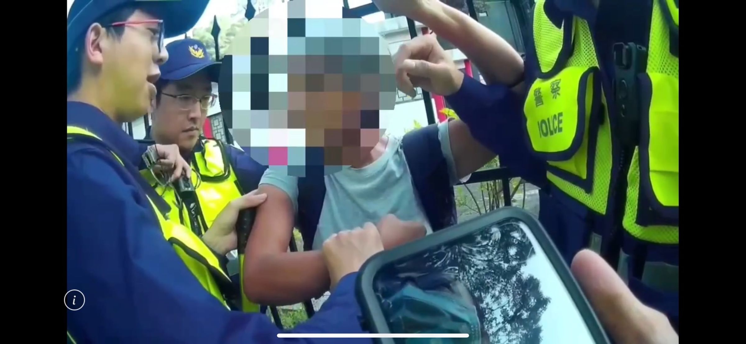 劉女在總統官邸附近的安全維護區持手機拍照,維安警方上前盤查、制止。(翻攝畫面)