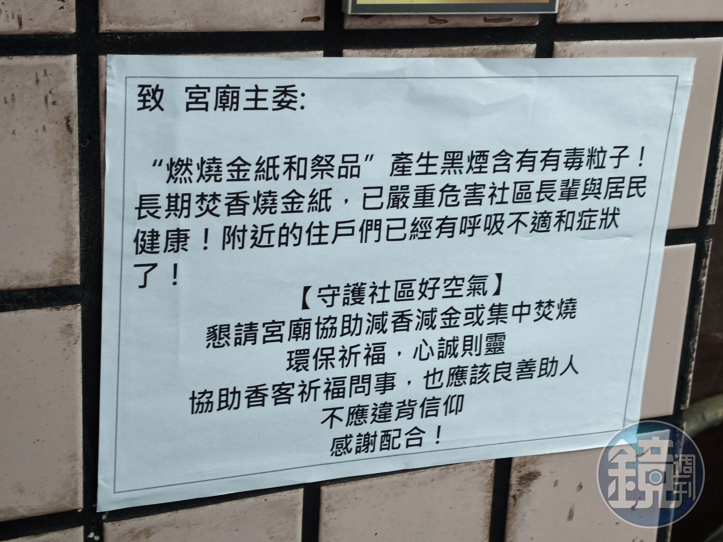 宮廟附近牆面貼著公告,寫著焚燒金紙與祭品產生的黑煙含有有毒粒子。(梁佑全攝)