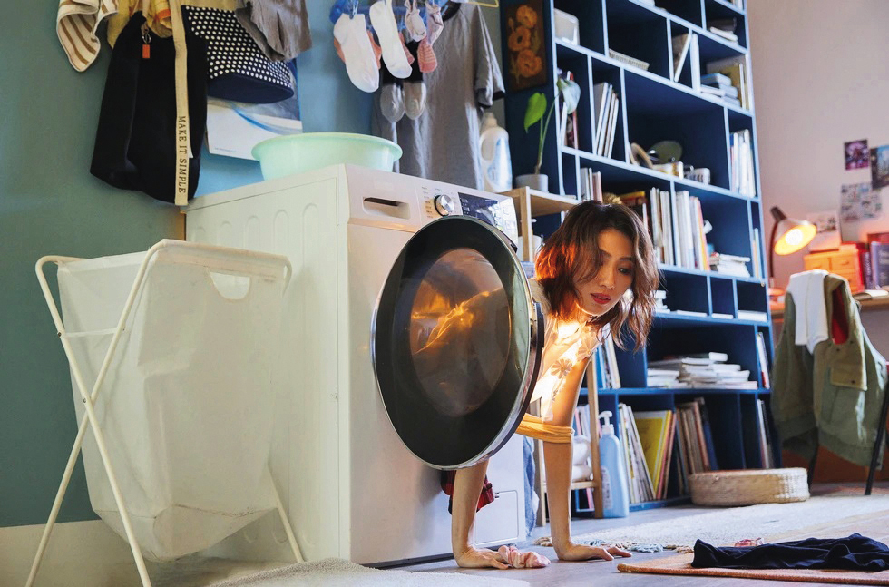 戴佩妮的歌曲MV〈多虧你啊〉由洪詩婷操刀，一場從洗衣機爬出來的戲逗趣可愛。（妮樂佛X仁仁娛樂提供）