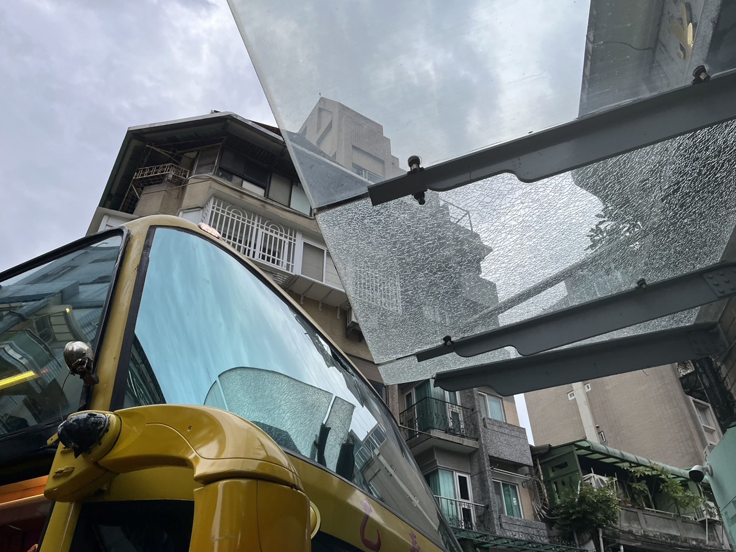 肇事遊覽車撞上光復市場遮雨棚,造成遮雨棚破裂損壞。(翻攝畫面)