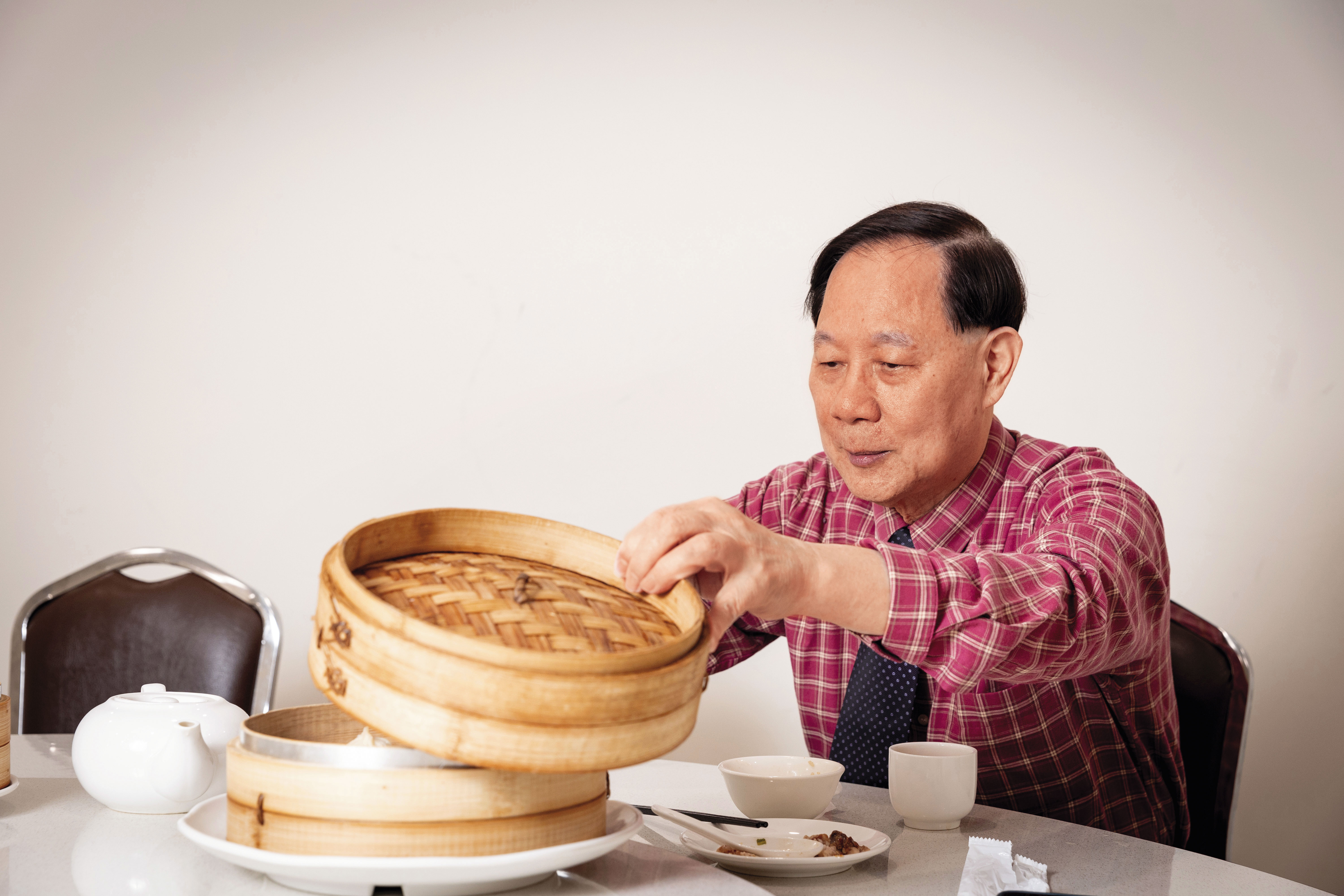 葉漢根夾完小籠包便蓋上蒸籠蓋，就怕涼了。