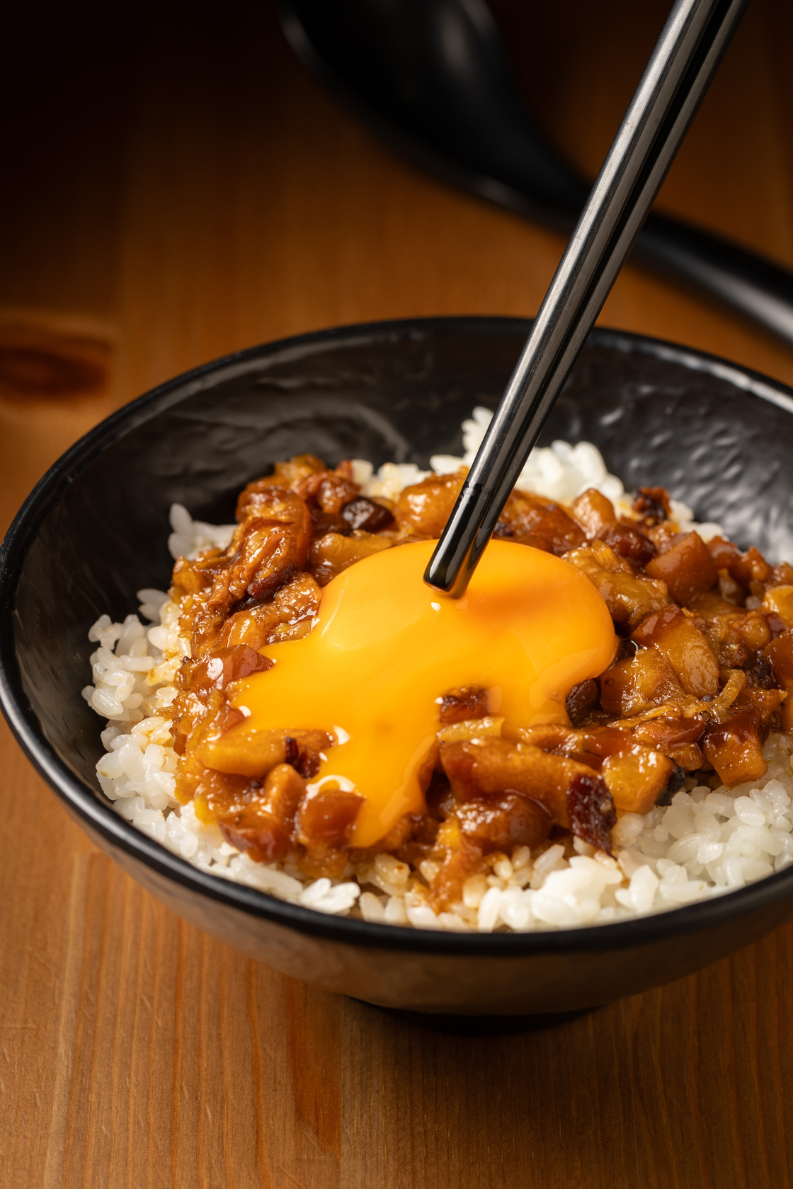 一筷子戳開「月見滷肉飯」，最精髓的蛋汁順著滷肉的縫隙流進米飯中。（60元／小碗、75元／大碗）