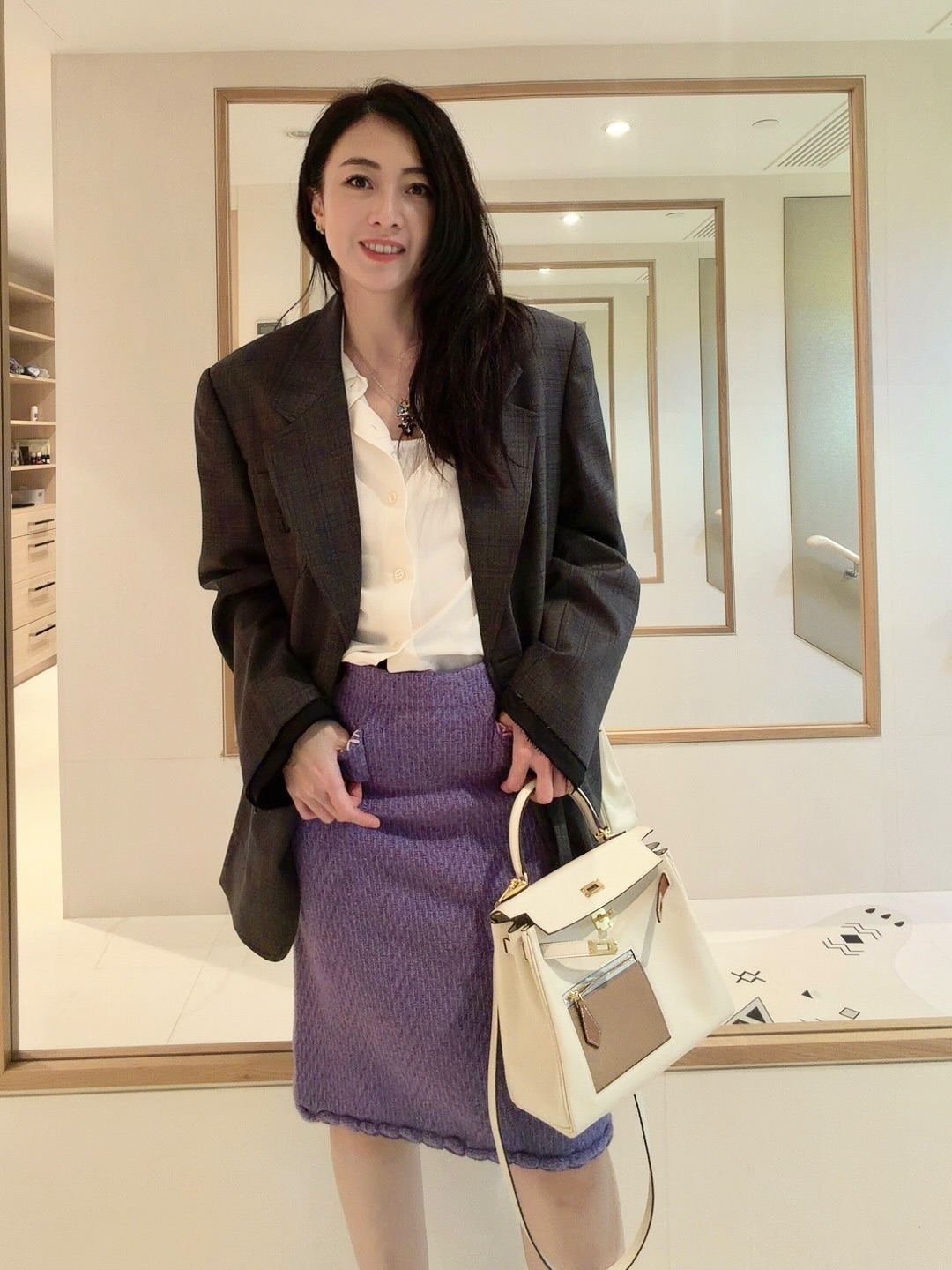 甘比穿著深灰色西裝外套搭配紫色及膝裙，拎著愛馬仕包。（翻攝kimbeechan_official IG）