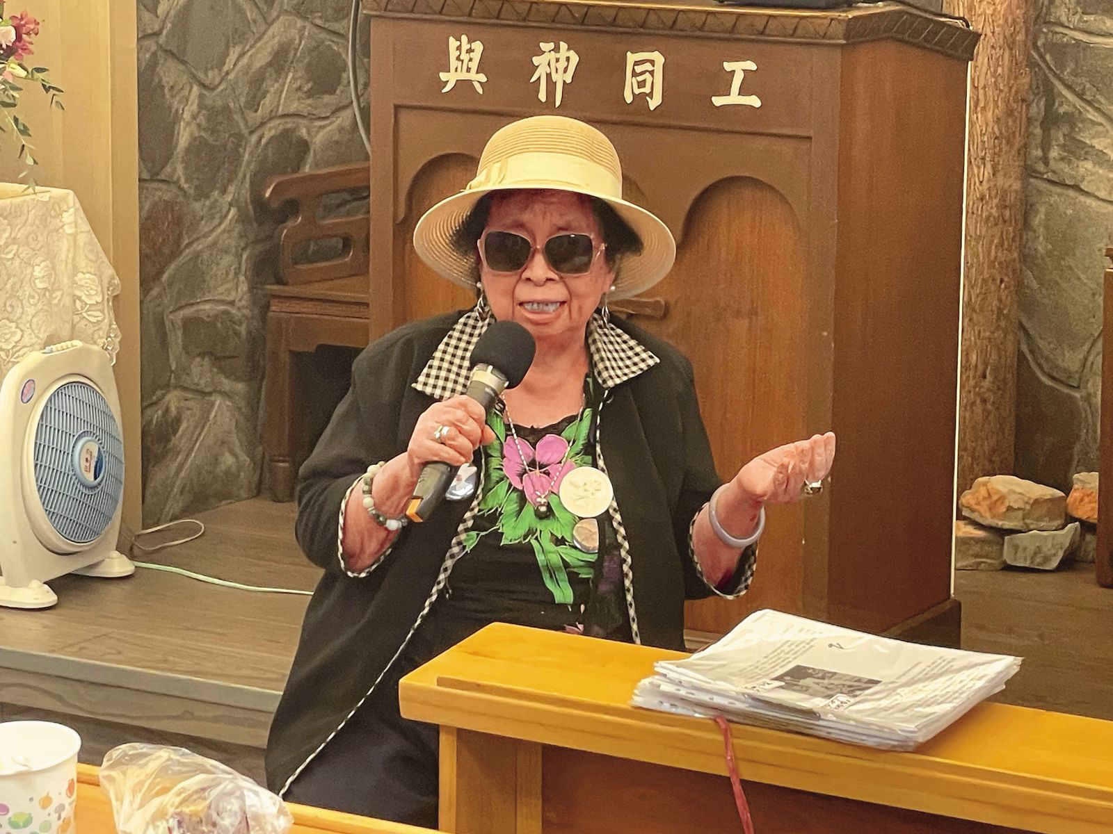 2024年6月，義光教會播放紀錄片《牽阮的手》時，田孟淑受邀在台前分享。她面前一疊紙，是精心製作的新聞紀念冊。（王銘澤提供）