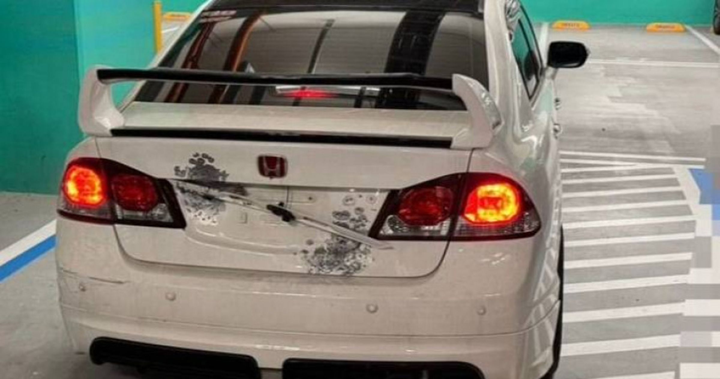白色本田轎車車燈遭槍擊炸裂,碎片散落現場,警方封鎖調查中。(翻攝畫面)