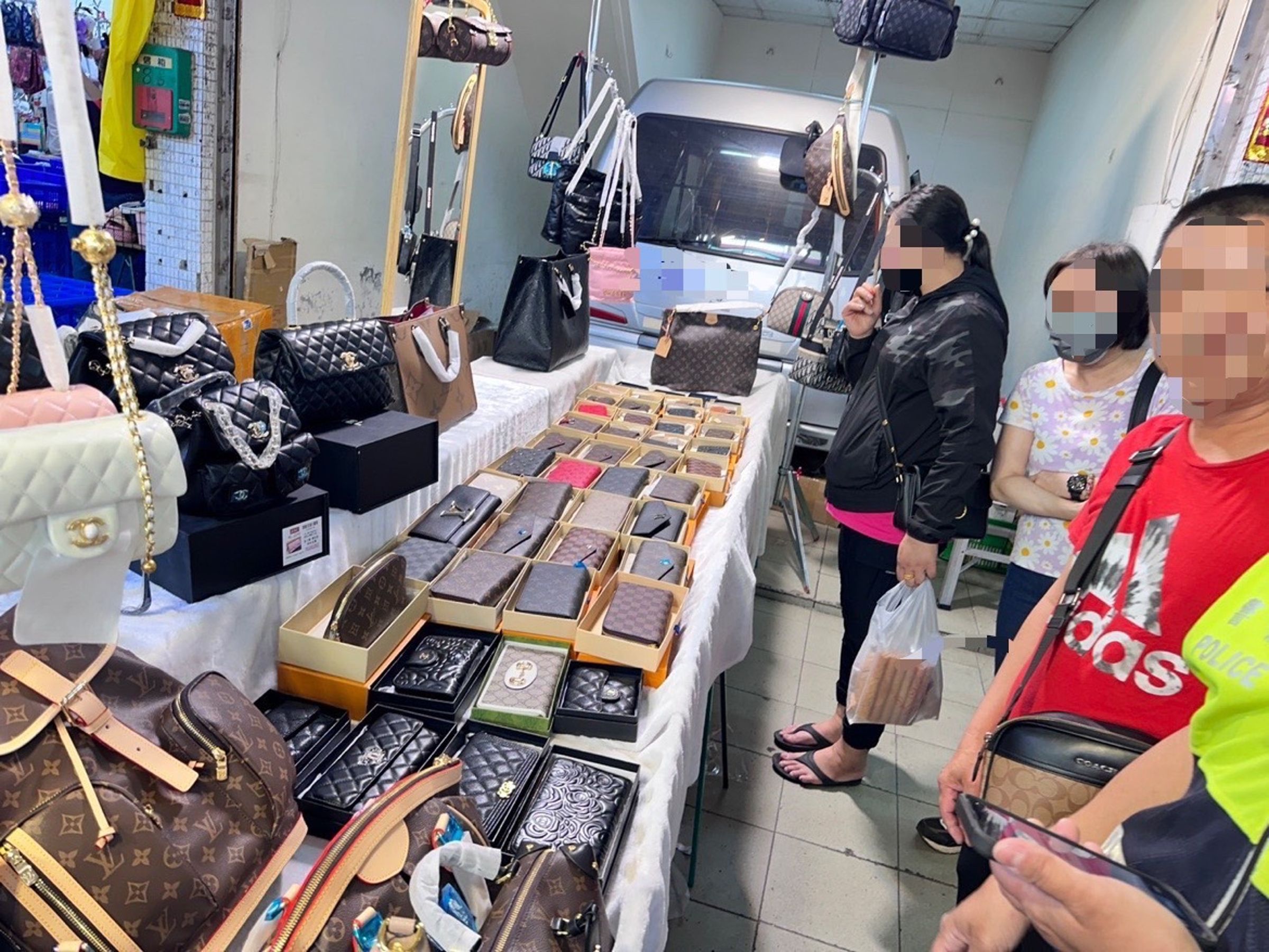 許姓攤販在高雄二苓市場,擺出LV、香奈兒等名牌包,初步認定非真品。(翻攝畫面)