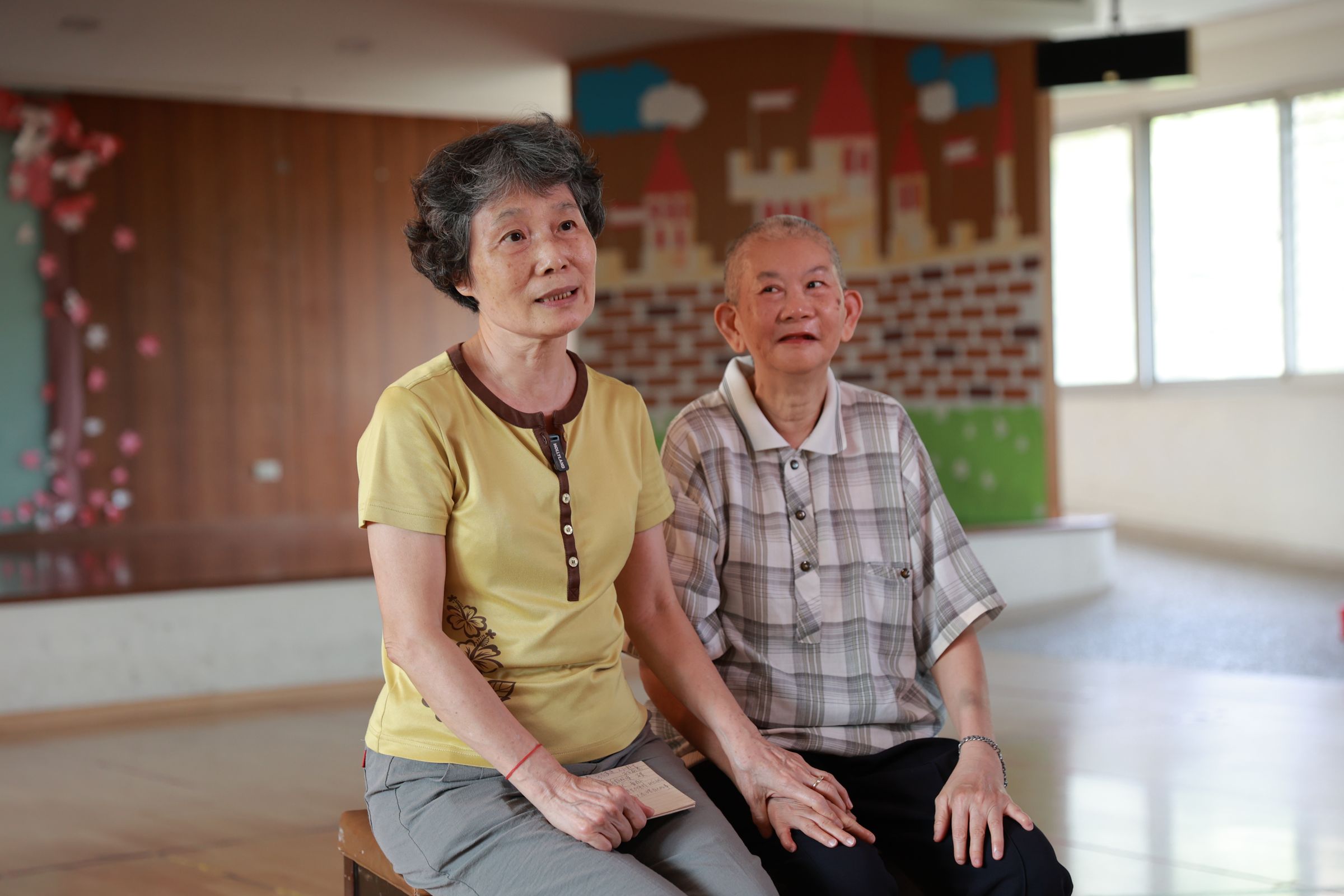 64歲的阿滄(右)因童年高燒導致智力停留在7歲,如今仍像個孩子般單純,照顧他的姐姐(左)已年逾七旬,開始擔心阿滄未來。(瑪利亞基金會提供)