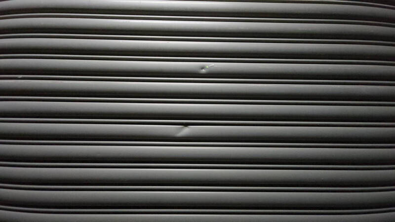 彰化縣議員楊竣程服務處鐵門被發現留下疑似彈孔痕跡，但未貫穿。（翻攝畫面）